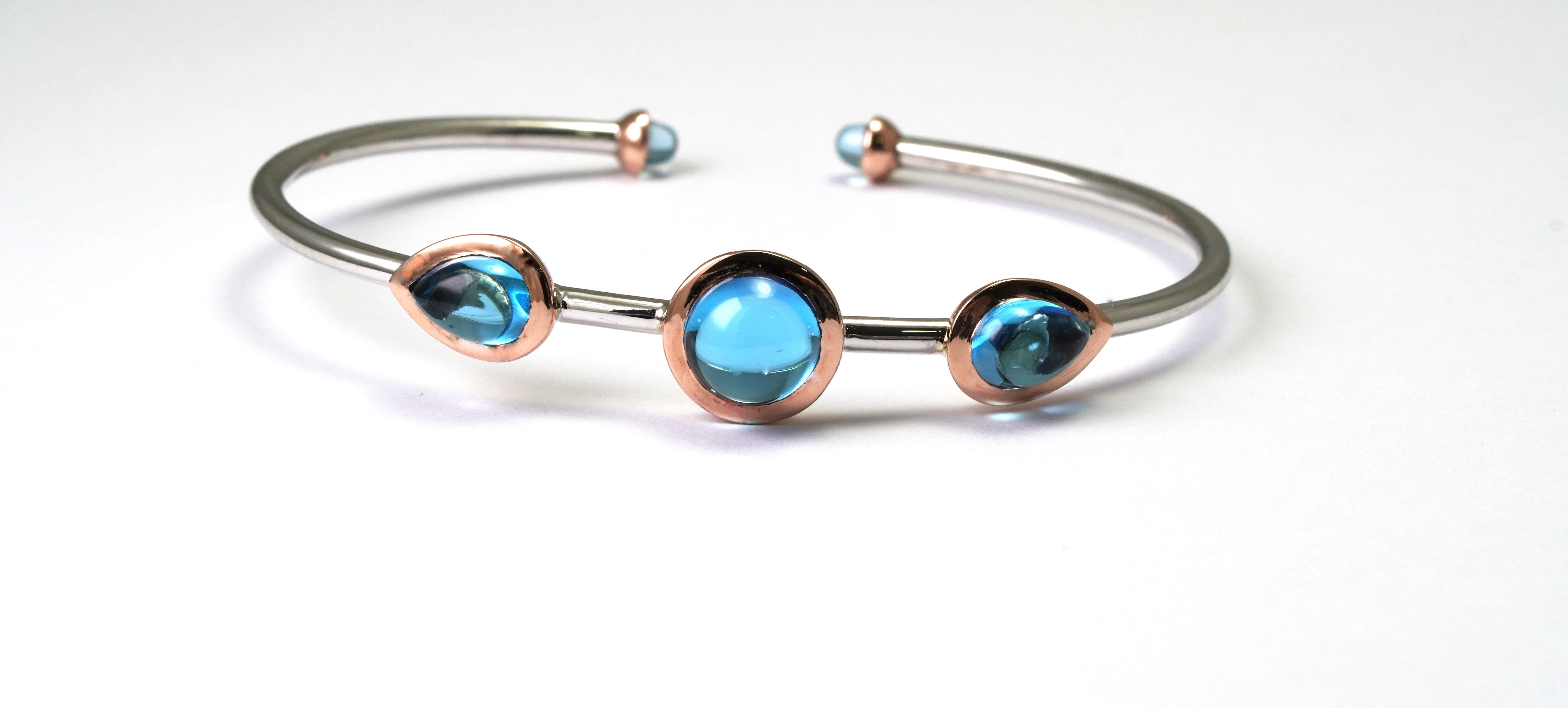 14 ct. White and Rose Gold Bracelet set with Swiss Blue Topaz.
Gold color: White and Rose
Dimensions: 53mm. x 41mm. 
Total weight: 5.94 grams 

Set with:
- Topaz (5 pieces)
Cut: Cabochon
Total Weight: 6.22 Carat
Color: Swiss Blue