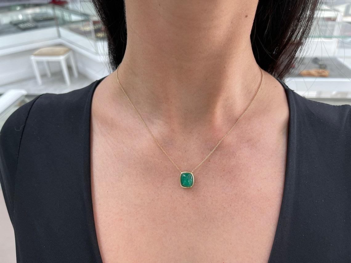 Gezeigt wird ein spektakulärer natürlicher Smaragd-Solitär-Anhänger. Dies ist das perfekte Statement-Stück mit dem prächtigsten Mittelstein. Der in der Erde abgebaute Smaragd ist ein kissenförmiger Cabochon, der in eine Fassung aus 14 Karat Gelbgold