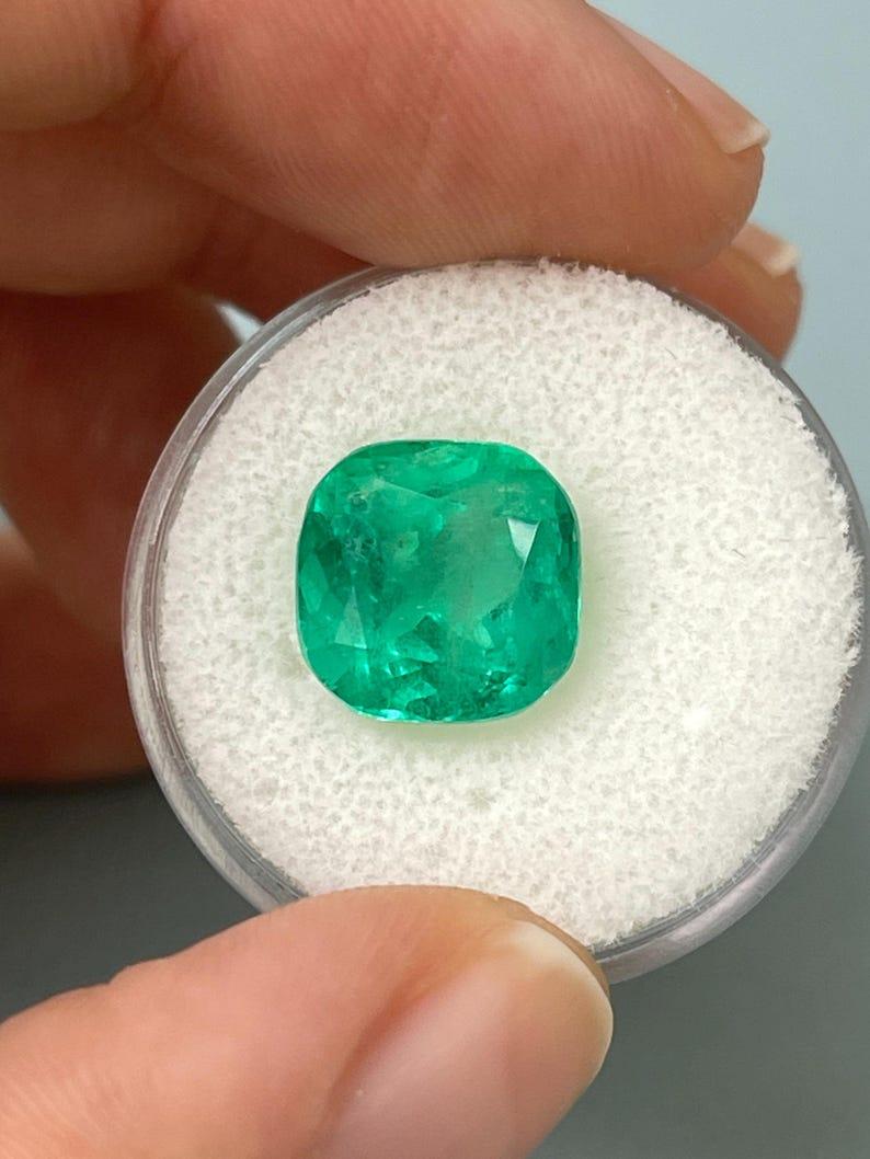 Stone: Emerald
Weight: 6.25-carats
Shape: Cushion Cut
Clarity: Transparent
Luster: Very Good
Color: Bluish Green
Measurements: 10.90mm x 10.85mm x 8.52mm
Geographic Origin: Colombia
Treatment: Natural, Oiling

Comments: Due to their growth