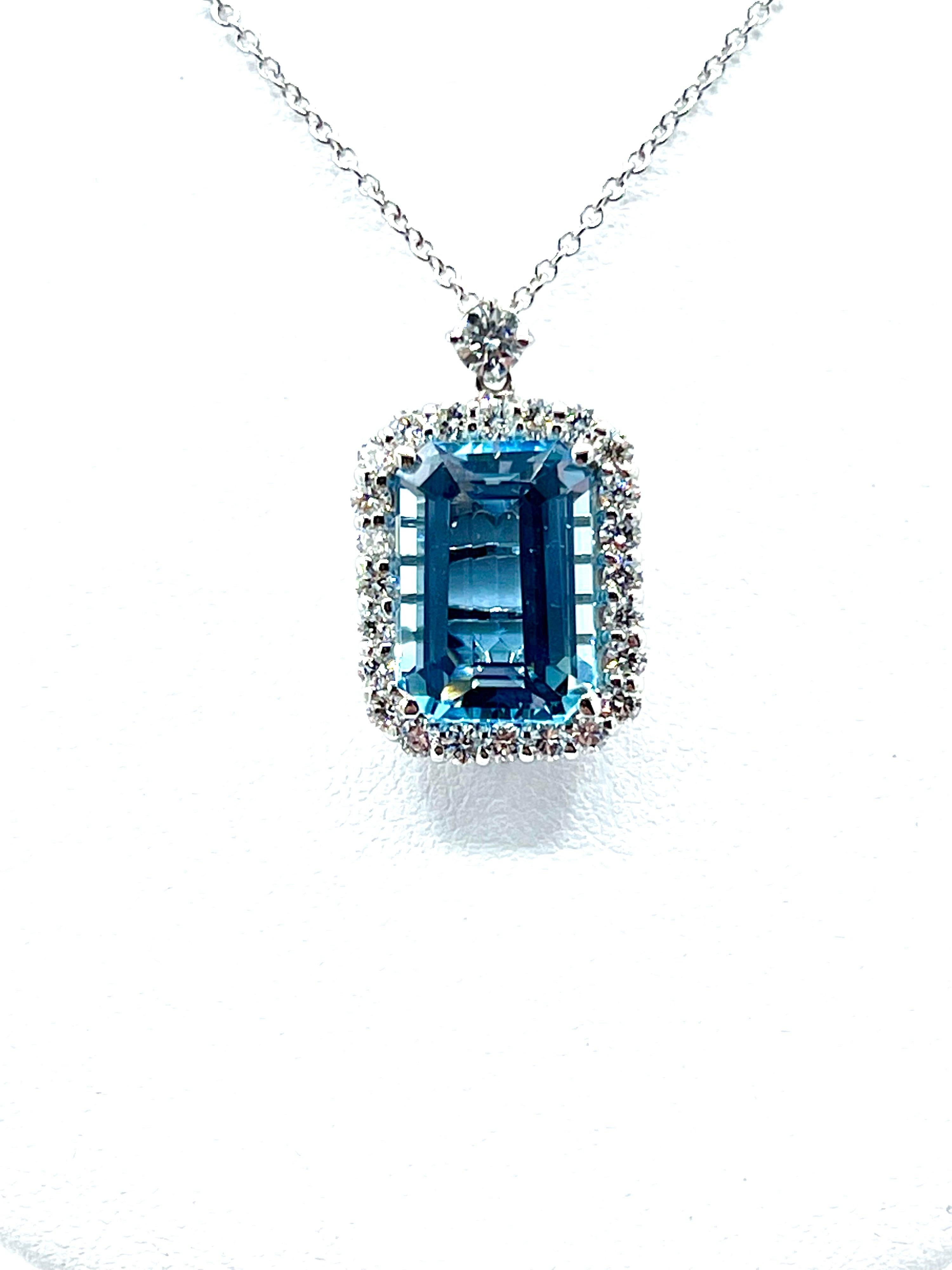 A gorgeous 6.25 carat emerald cut Aquamarine necklace.  The Aquamarine has a stunning brilliance and color.  it is set in four prongs, with a single row of round brilliant Diamonds surrounding, and one Diamond on top as part of the bale.  There is a