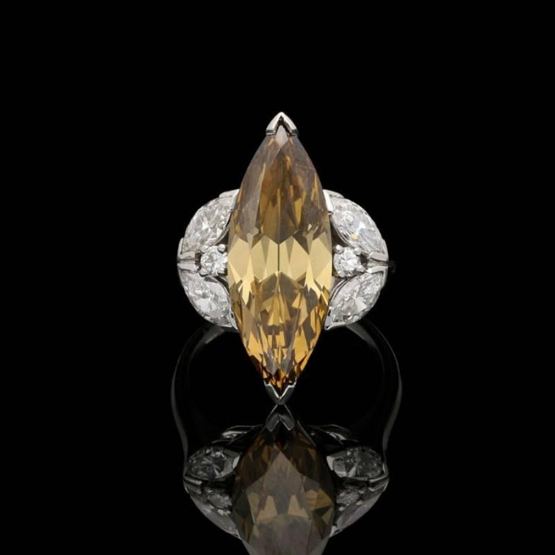An elegant fancy coloured diamond ring c.1950s, set to the centre with a beautiful elongated marquise diamond weighing 6.26 carats and of fancy deep brown-yellow colour set to either end with a simple V-claw within an open gallery between