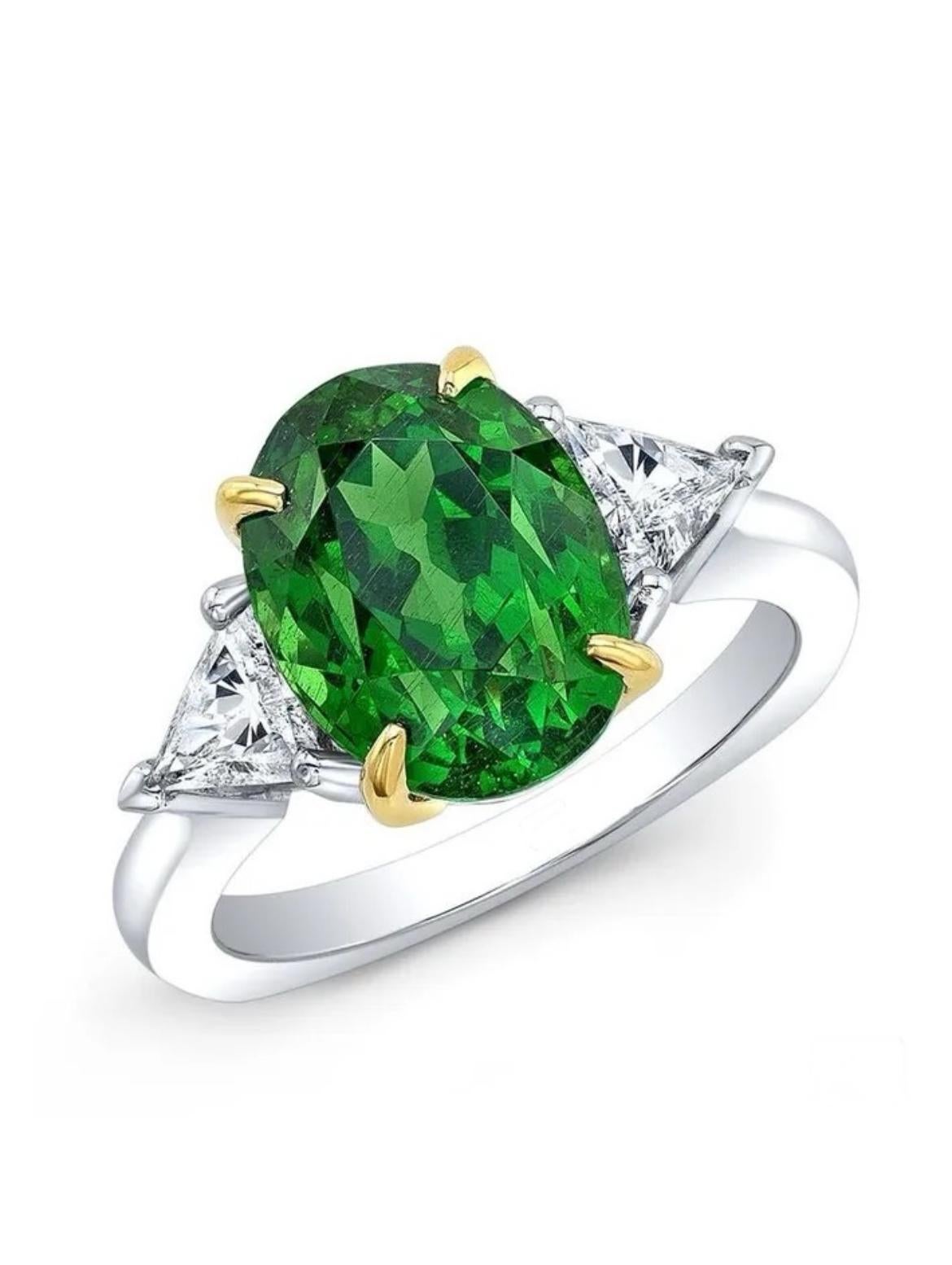 Exceptionally rare 6.26-carat, Tsavorite Garnet is flanked by two trillion-cut diamonds totaling 0.51 carats. This absolutely gorgeous, vibrant, and electric Tsavorite is presented in platinum with 18K yellow gold and is GIA certified. 