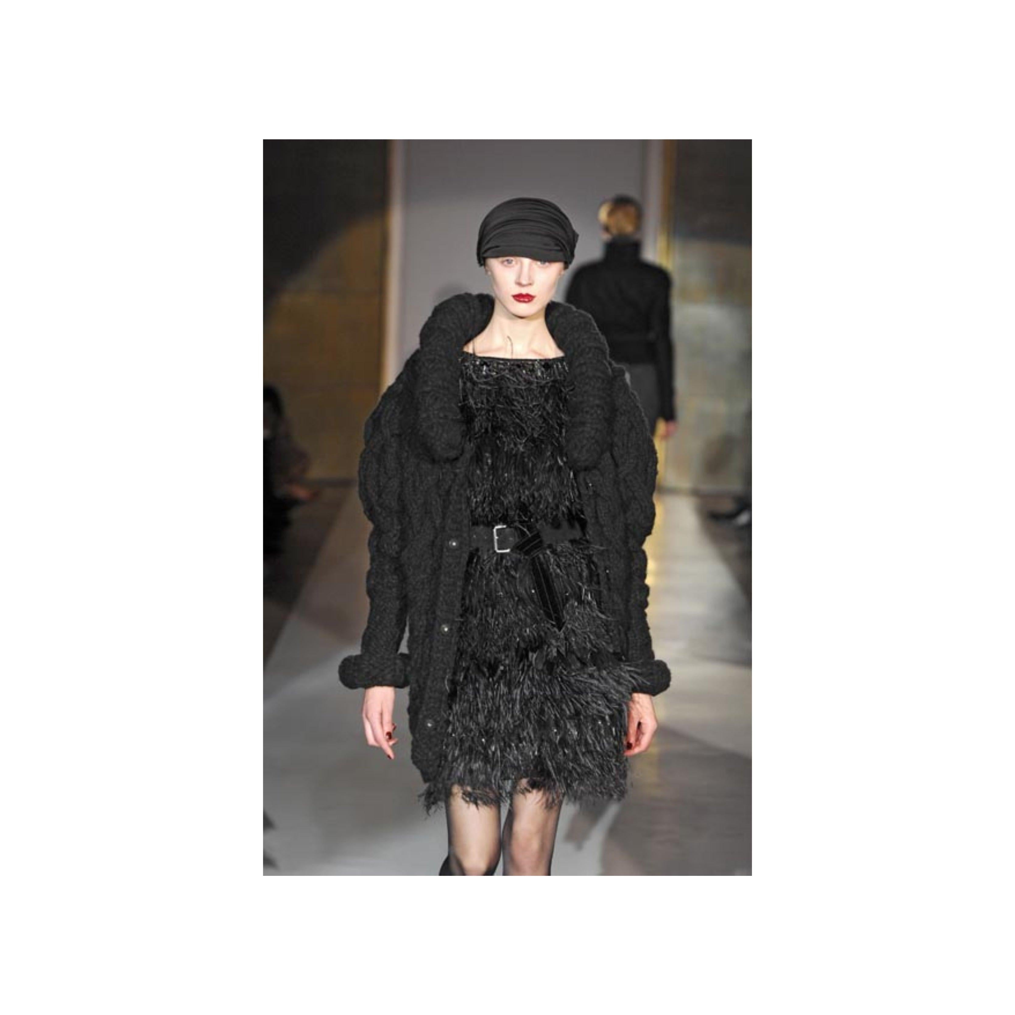 This gorgeous 6267 Feather Embroidered Dress from the Fall Winter 2007 collection has been crafted using a blend of virgin and Angora wool. The dress features an eye-catching design covered with exotic feathers, beads, and embellishments, and a
