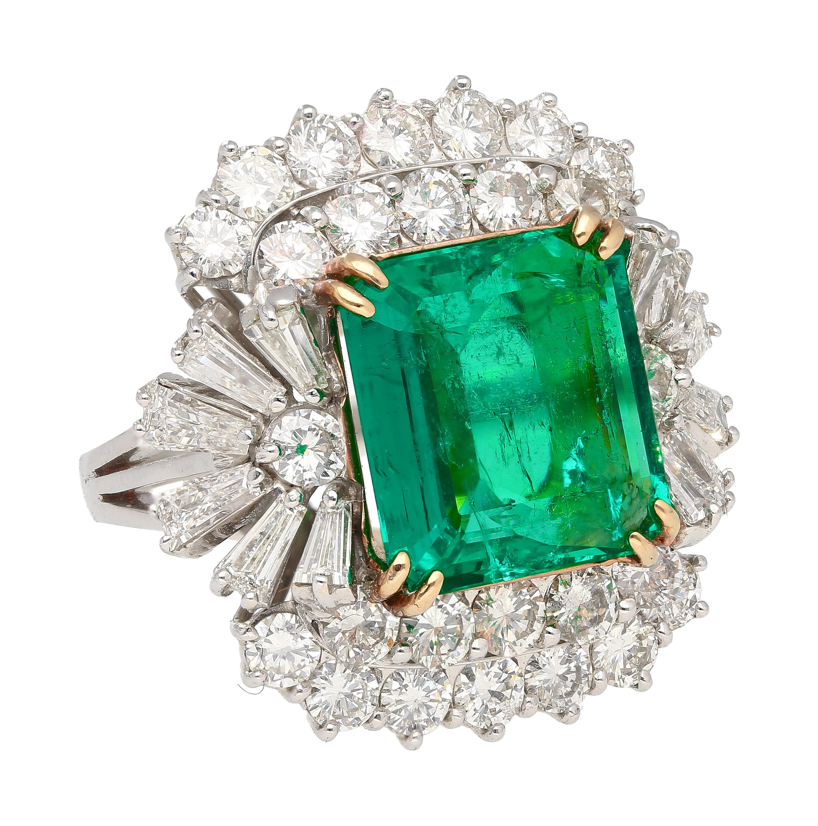 18K White and Yellow Gold two gold-toned emerald and Diamond Ring. A true masterpiece weighing 9.68 grams and 10.66 carats in natural mined gemstones. At its heart lies a captivating 6.26-carat emerald-cut Emerald, a gem of natural beauty with