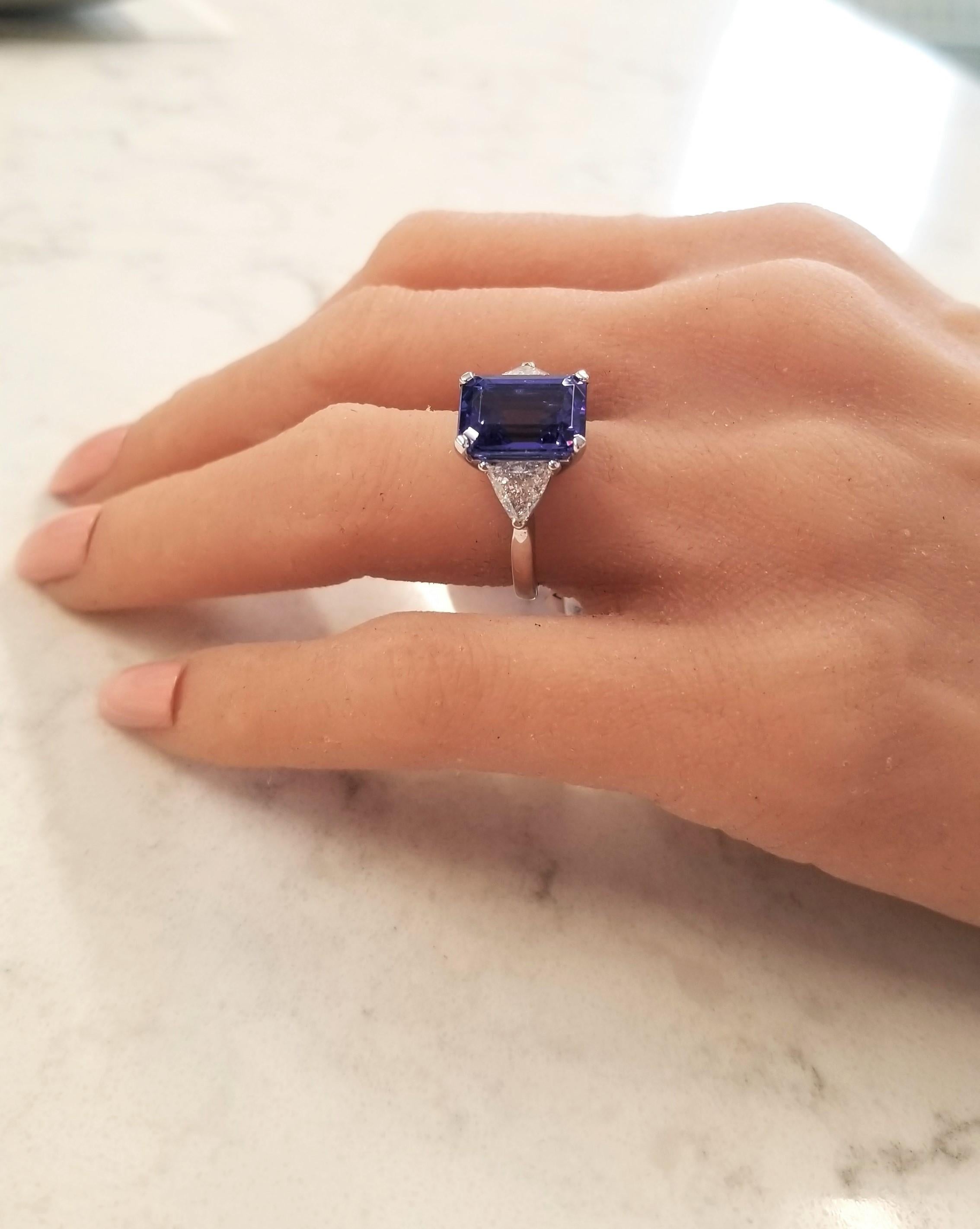 A ravishing deep violet-blue tanzanite weighing 6.27carat, emerald cut, measuring 12.10 x 9.06 mm is the eye catching highlight of this ring. The foothills near Mt. Kilimanjaro in Tanzania produce gems with this most sought-after clarity and
