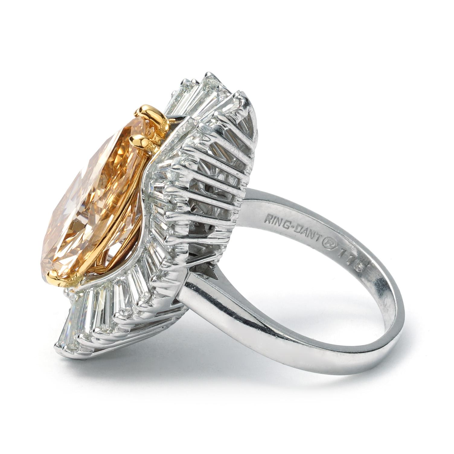 This New York Jewelers Signature ring is made of platinum and weighs 10.8 DWT (approx. 16.8 grams). It contains one GIA Certified pear shaped diamond weighing 6.28 CT with a fancy brownish yellow color, 36 tapered baguette G-H color and VS clarity