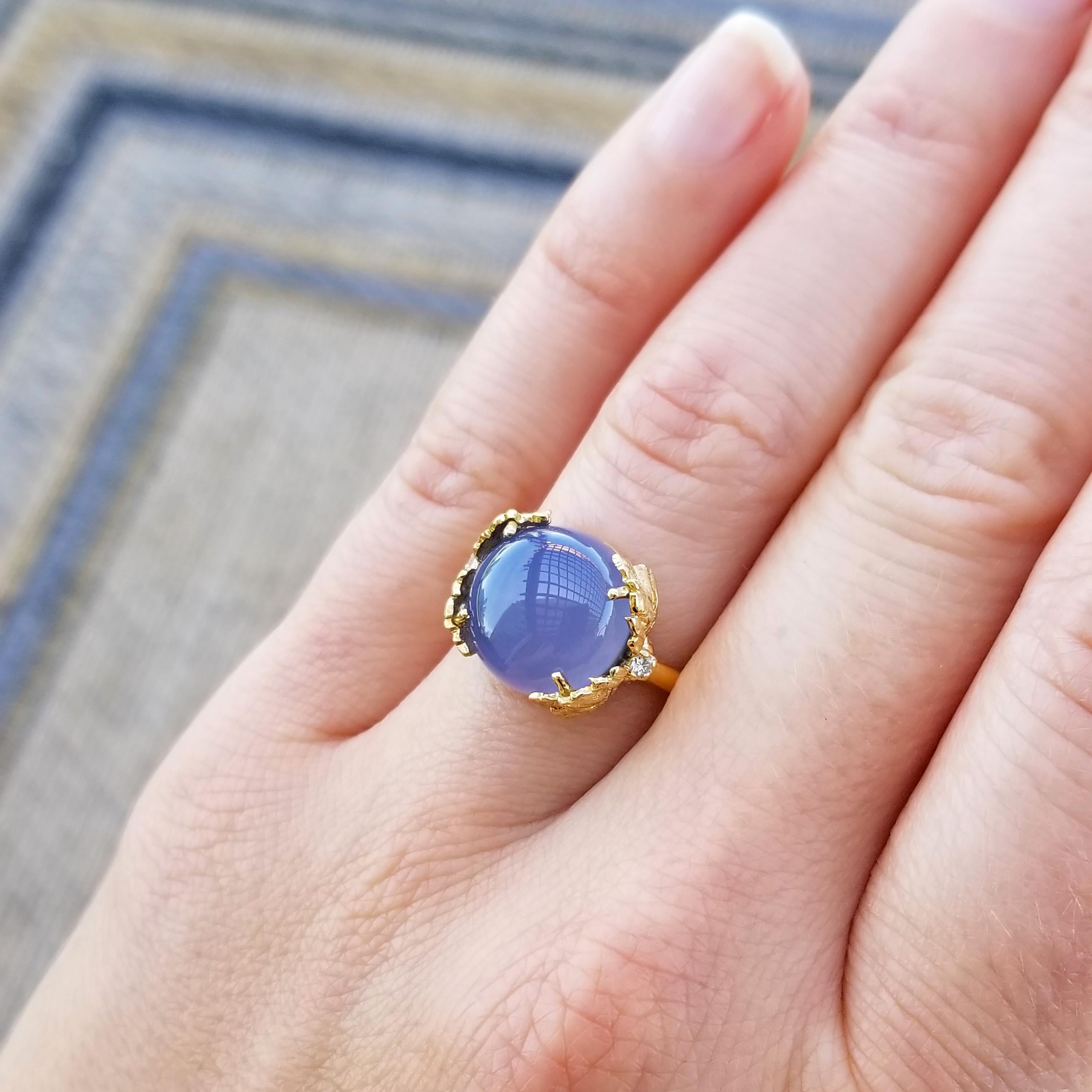 Chalcedony in a richly saturated violet blue nestles elegantly in the leaves of this custom Florentine engraved handmade 18kt ring. The soft translucence of this top quality Namibian chalcedony allows the light to play through the gemstone.

The