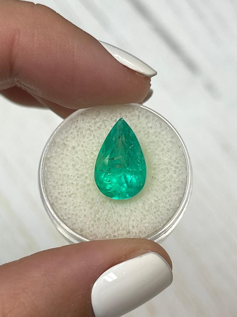 Stone: Emerald
Weight: 6.28-carats
Shape: Pear Cut
Clarity: Transparent
Luster: Very Good
Color: Vivacious Yellowish Green
Measurements: 14.95mm x 9.71mm x 8.51mm
Geographic Origin: Colombia
Treatment: Natural, Oiling

Comments: Due to their growth