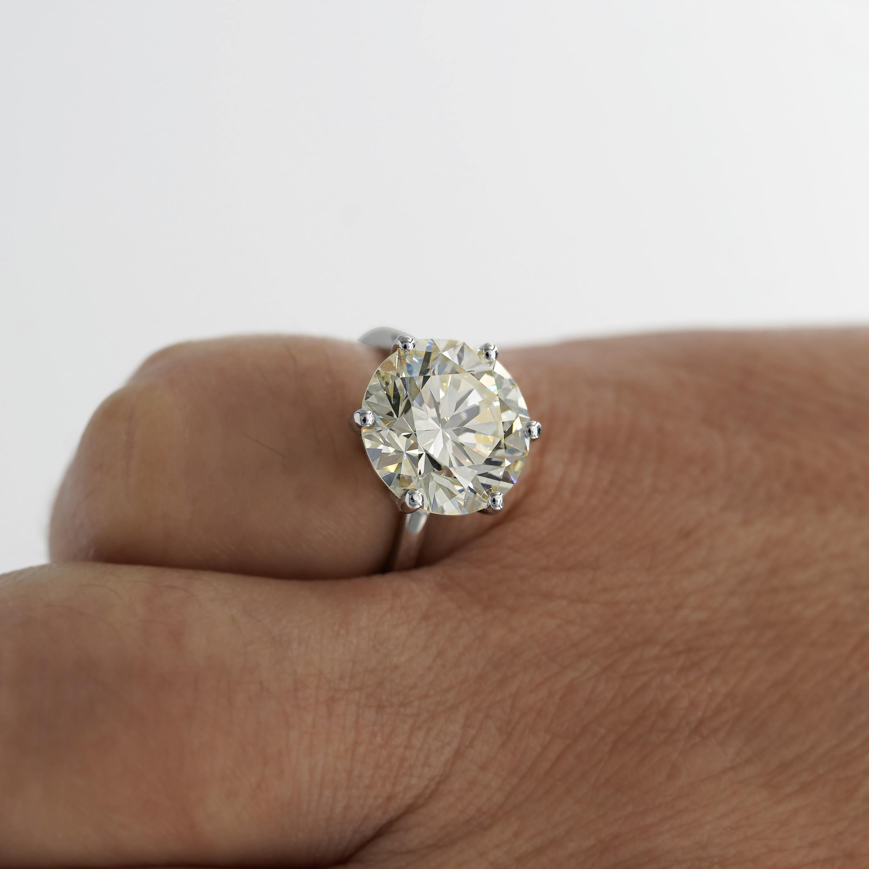 6.29-carat natural diamond solitaire engagement ring set in 14K white gold, featuring a vintage-inspired 6-prong crown basket setting for an effortlessly antique look. The diamond exhibits a charming warm color with eye clean clarity and excellent