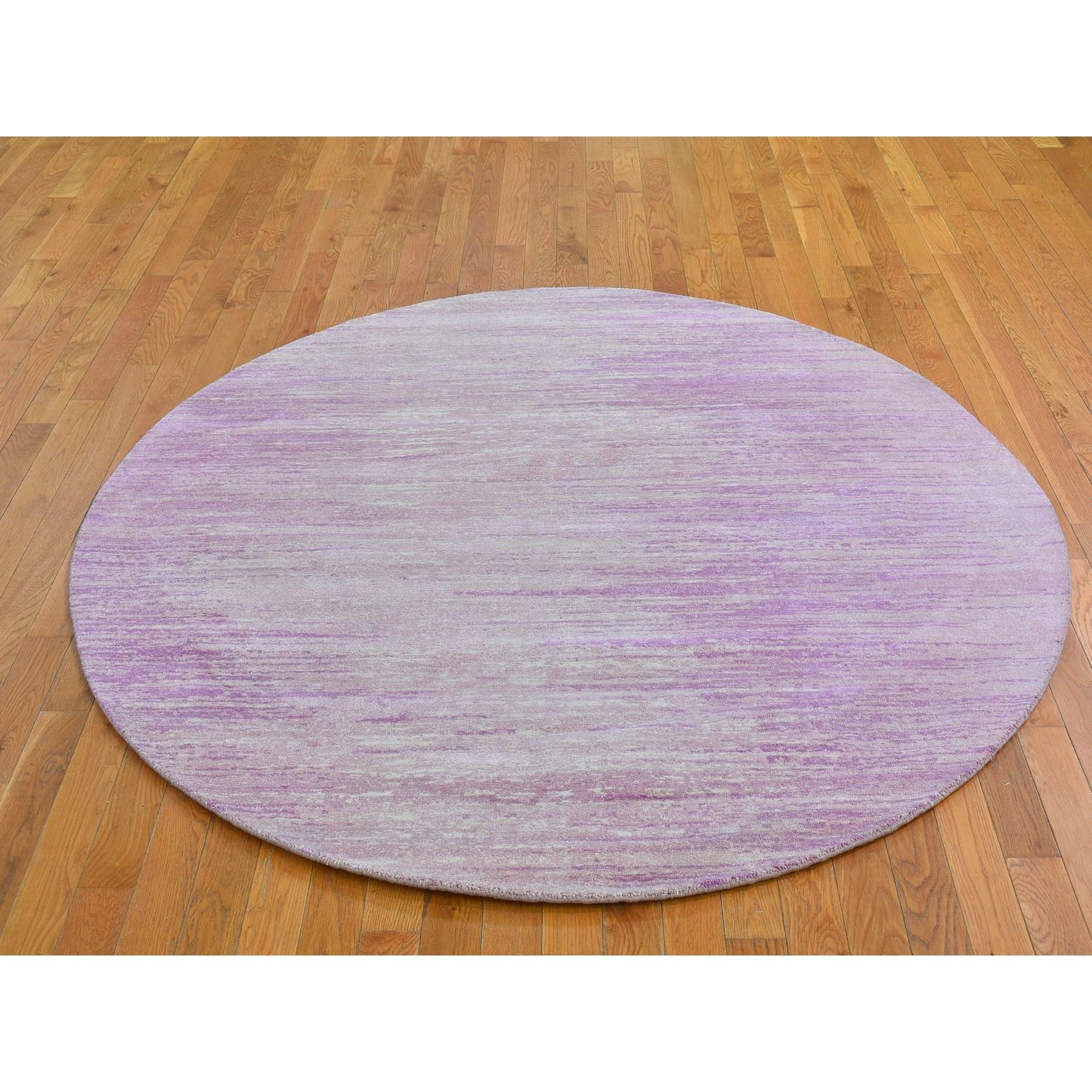 Il s'agit d'un véritable tapis oriental rond noué à la main, en laine organique rose épaisse et pelucheuse, avec un design horizontal en forme d'ombre. Il a été tissé pendant des mois et des mois selon les techniques séculaires de l'artisanat persan