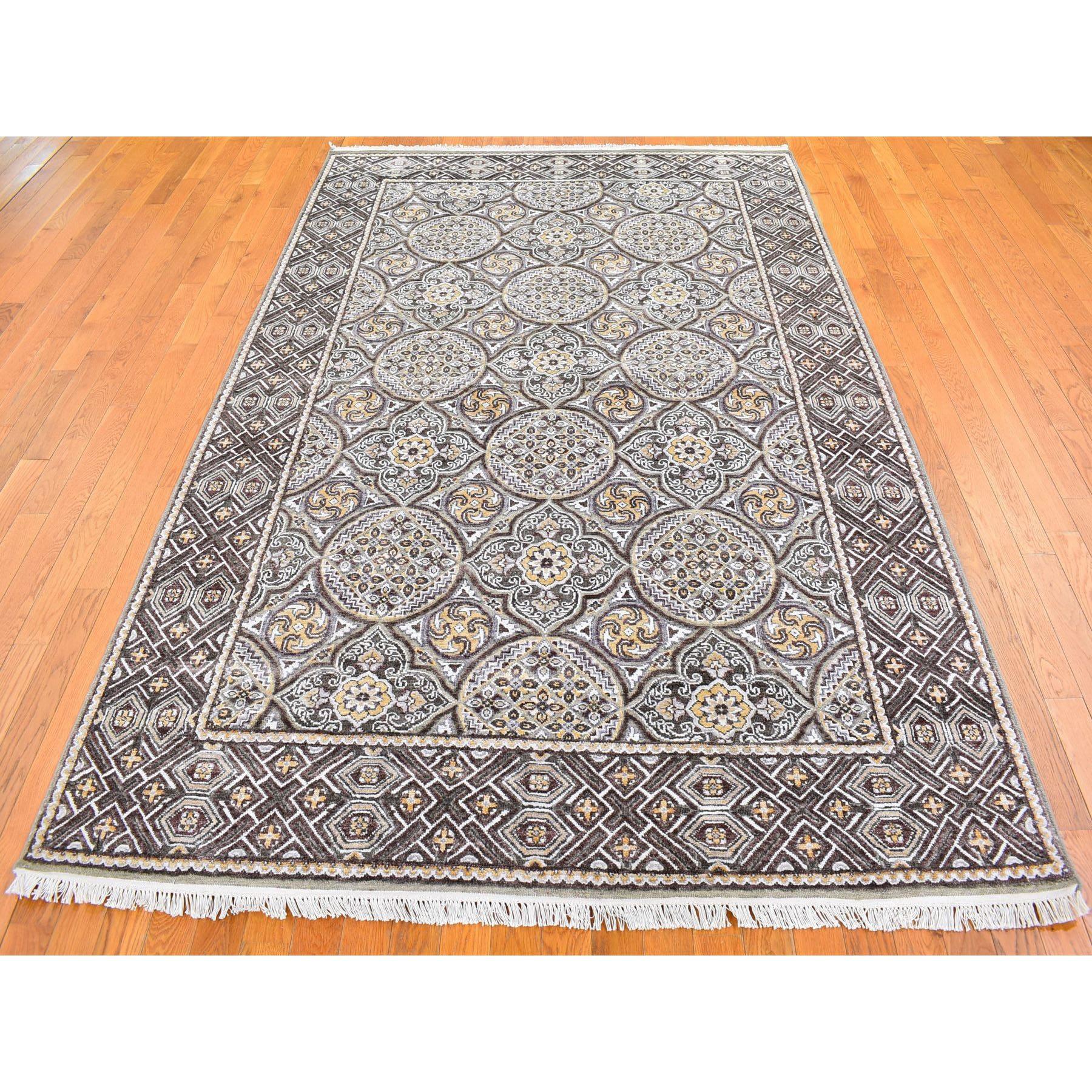 Il s'agit d'un véritable tapis d'Orient noué à la main, en laine et soie texturée brune et à motifs de médaillons d'inspiration moghole. Il a été noué pendant des mois et des mois selon les techniques séculaires du tissage persan par des artisans
