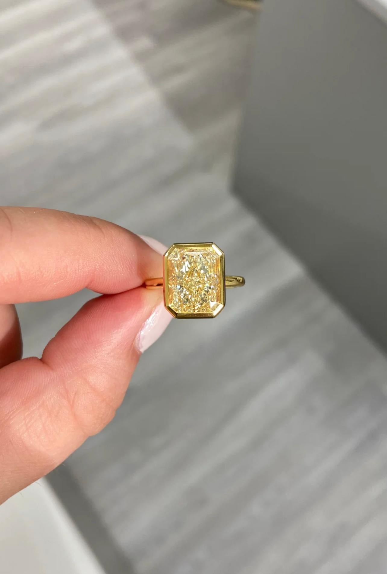 Spready 6ct long radiant certified as a UV color VS clarity
Set in an 18kt Yellow Gold bezel ring to bring out the color with a clean and sleek design 
