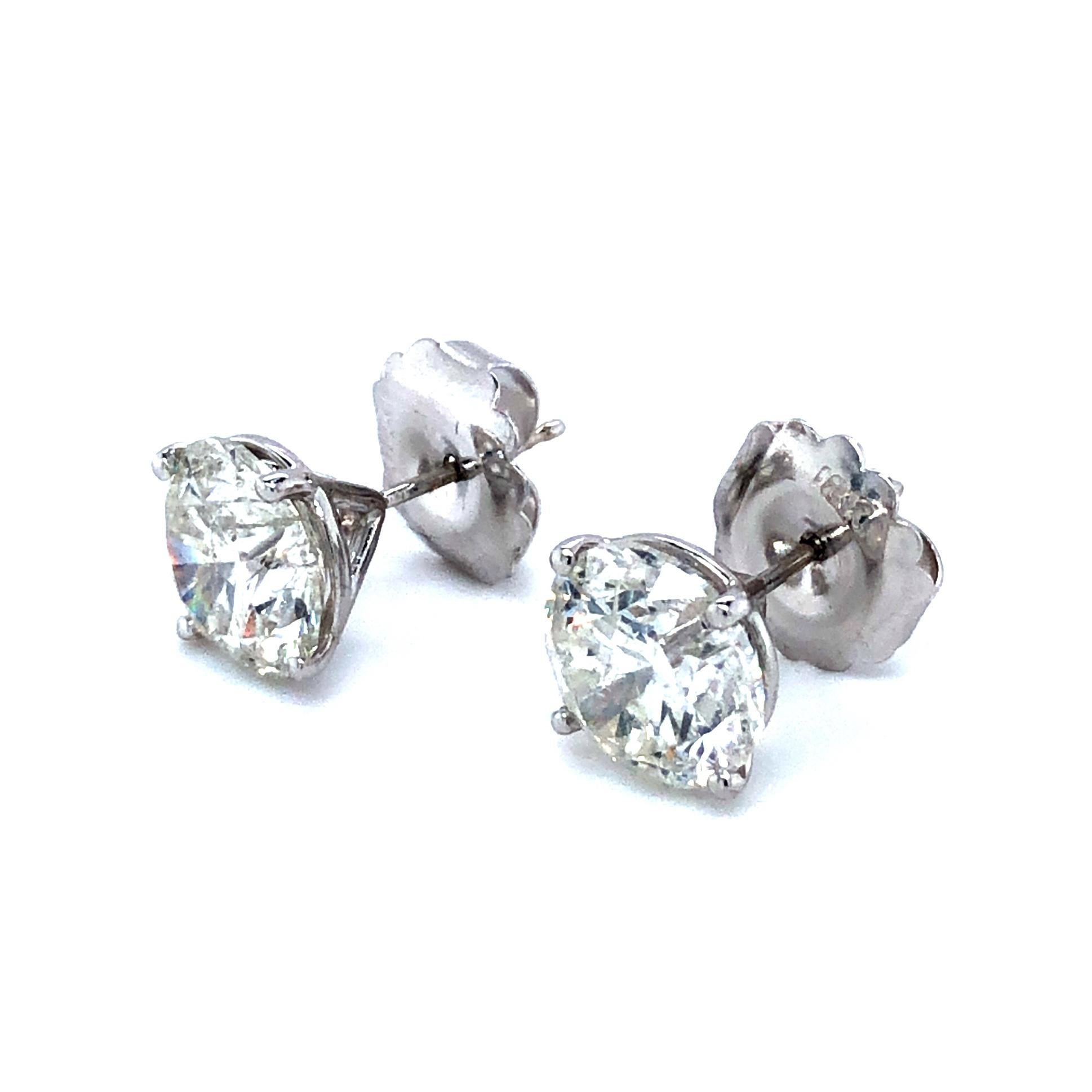 Offered here is a classic diamond studs set in 18k white gold. The diamonds are natural round brilliant cut H color and Si3-I1 with a total weight of 6.31 carats. The diamond are set in four prong martini settings ( stamped 18k on the heavy push