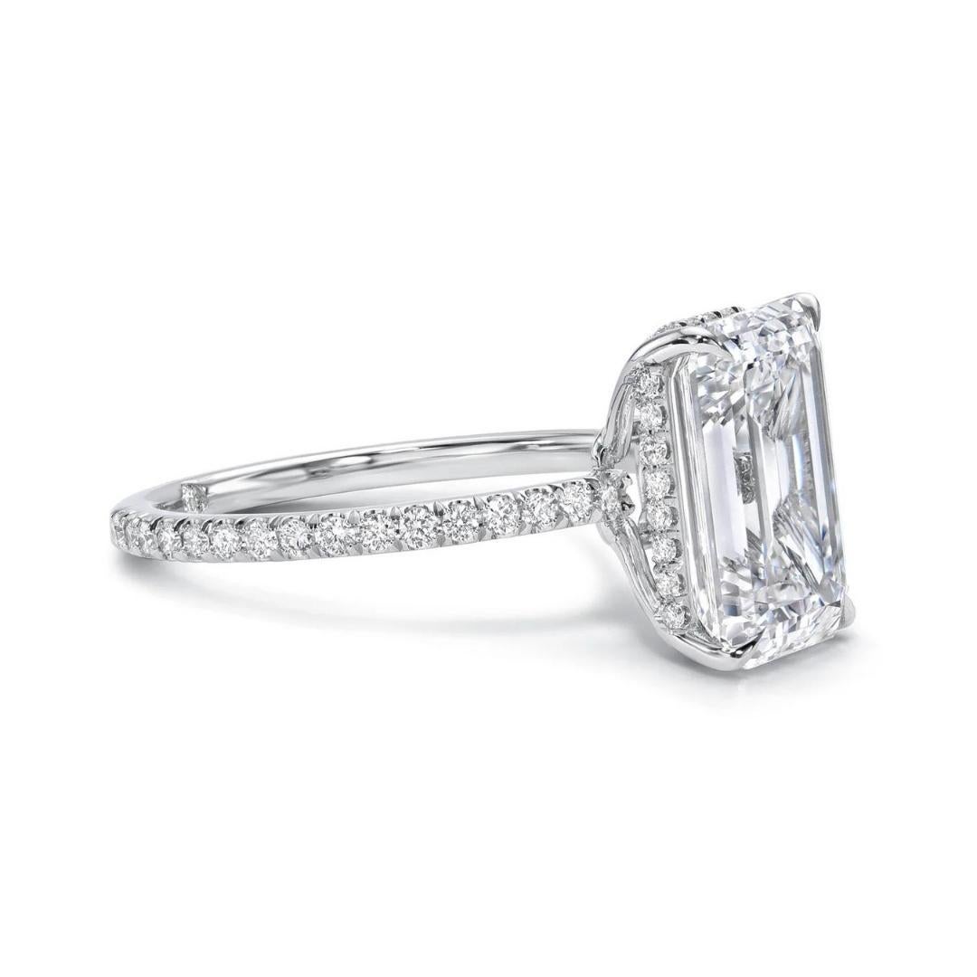 A sumptuous 6.32 carat Emerald cut diamond ring, set in platinum with a hidden pave basket and ¾ of pave in the band. This magnificent GIA Certified center stone displays centered tables and no extra or missing facets giving the emerald cut diamond