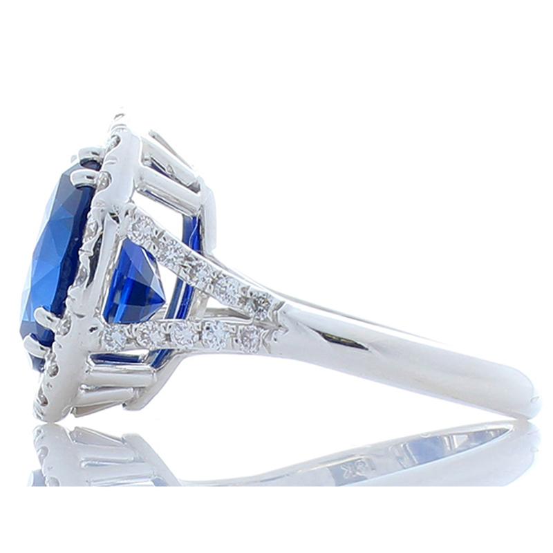 This is a 6.32 carat - 11.36 x 9.84 millimeter royal blue sapphire that is surrounded by a stunning halo of round brilliant diamonds. The sapphire is from Sri Lanka. The color is royal blue; its luster, clarity, and transparency are exceptional. The