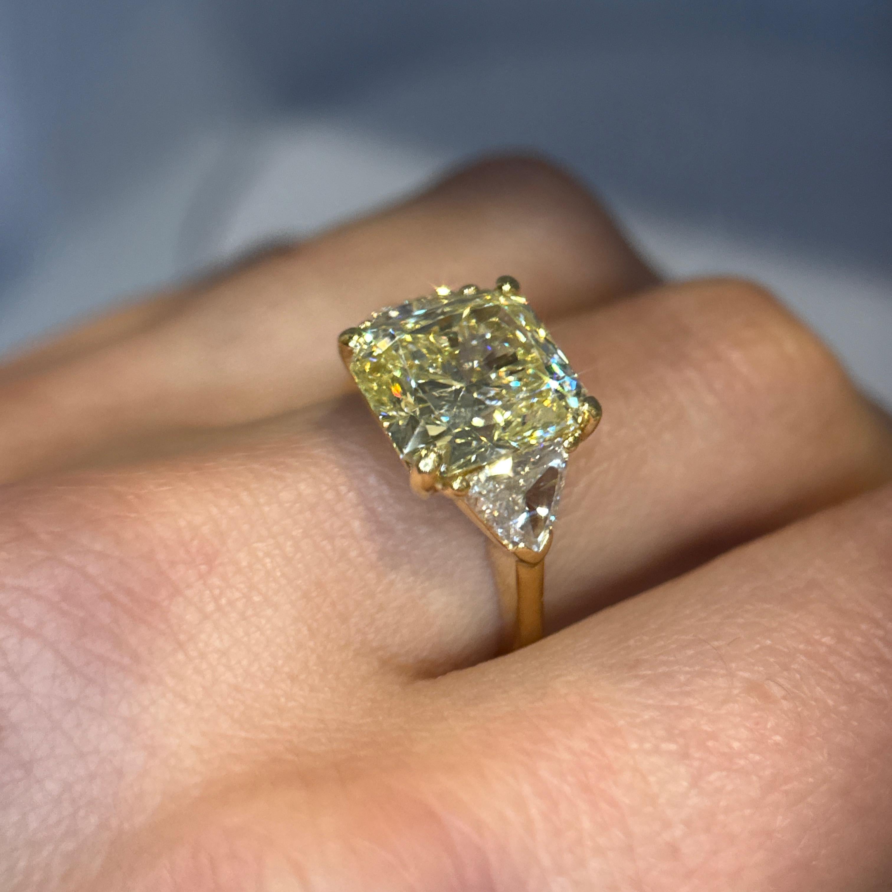 Compromiso femenino de oro amarillo de 18 quilates con engaste de tres piedras. Un diamante de talla radiante de 11,1 x 10 x 6,9 mm y 6,32ct Amarillo Fancy VS1 (GIA #2235118094)  y 2 diamantes talla trillón 6 x 6,7 x 2,2 mm (otros 2,55 mm) diamante