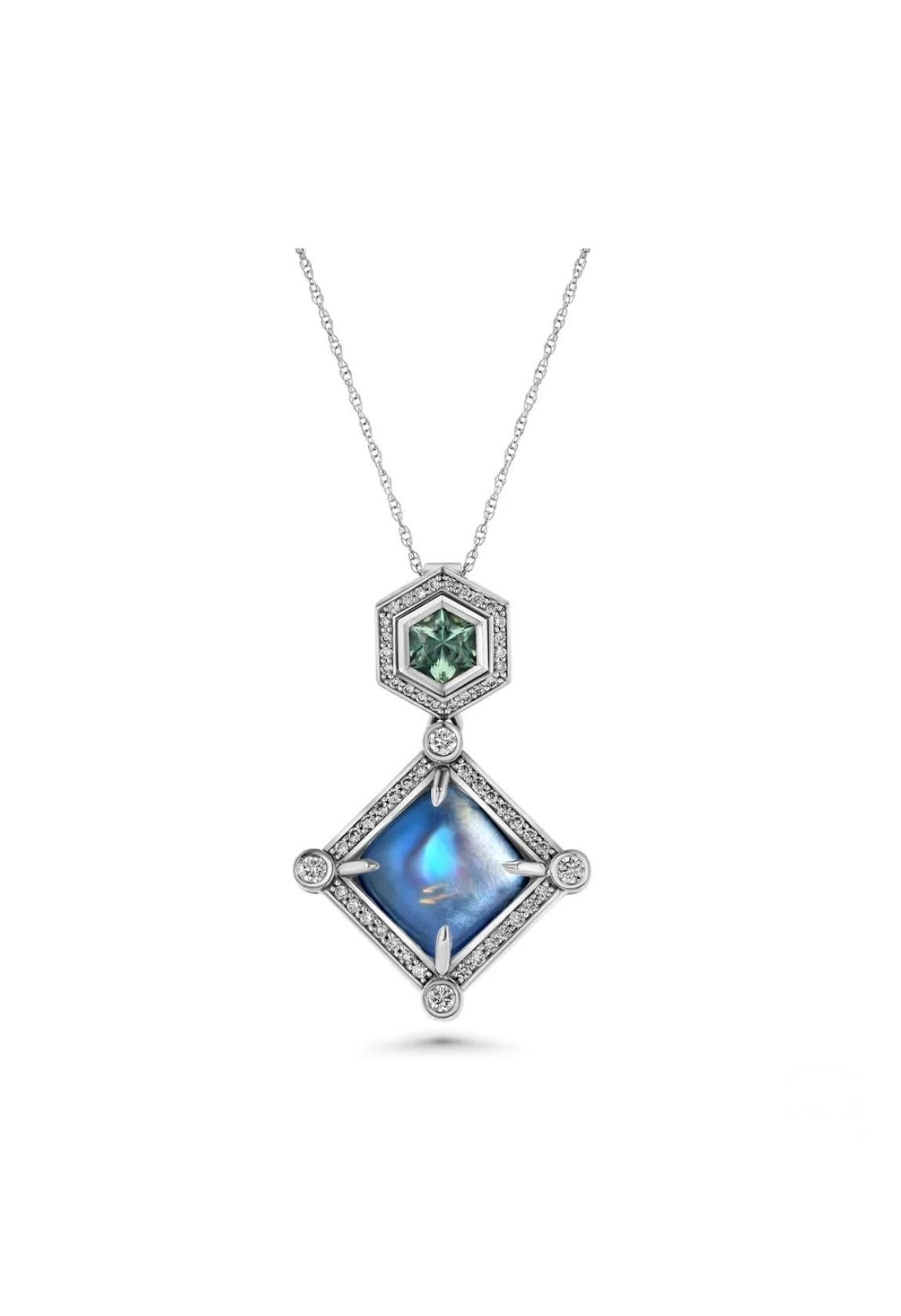 A glowing 6.36-carat, rainbow Moonstone shines with a 0.53-carat, hexagon-cut Montana Sapphire, highlighted with round diamonds totaling 0.38 carats in 18K white gold pendant. 