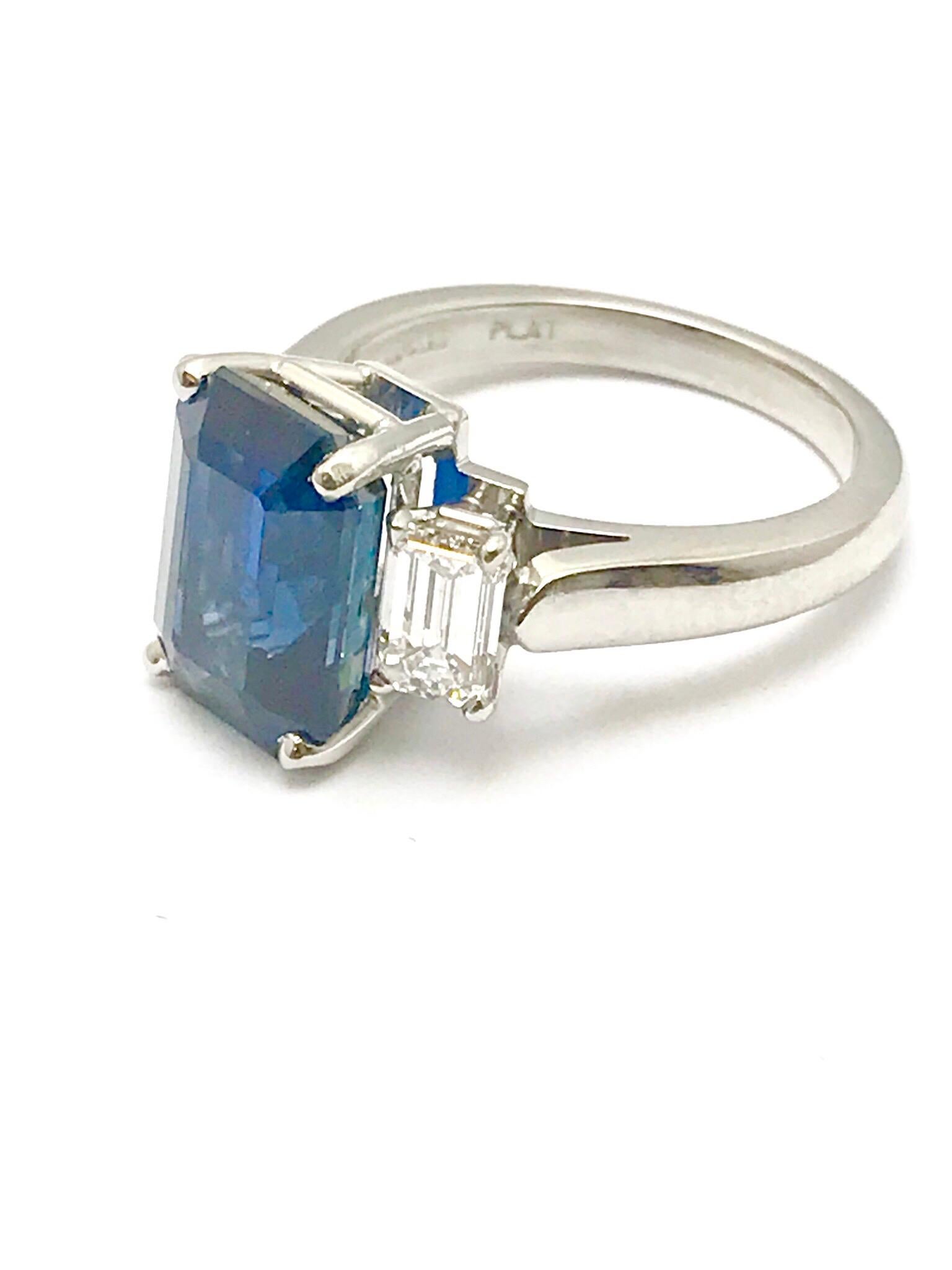 A stunning 6.51 carat emerald cut natural sapphire and emerald cut diamond ring set in platinum.  The sapphire is set in a four prong basket, with one emerald cut diamond on each side.  The sapphire is accompanied by a report from American