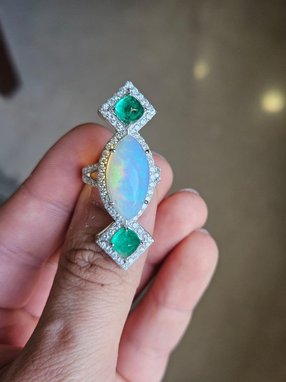 A very gorgeous and beautiful, Emerald & Opal Cocktail Ring set in 18K White Gold & Diamonds. The weight of the Marquise shaped Cabochon Opal is 6.37 carats. The Opal is of Ethiopian origin. The weight of the Emerald sugarloaf is 2.54 carats. The