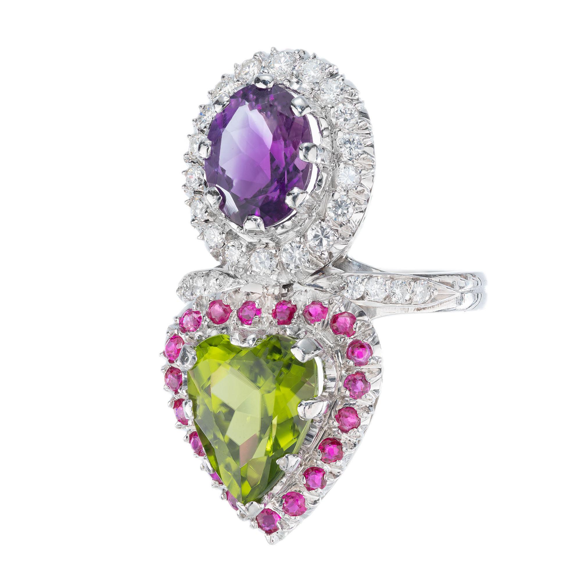 Peridot, ruby, amethyst and diamond cocktail ring. Oval amethyst with a halo of round diamonds. Heart shaped peridot with a halo of round rubies. Set in platinum with accent diamonds on the shank. 

1 heart shaped gem natural bright green Peridot,