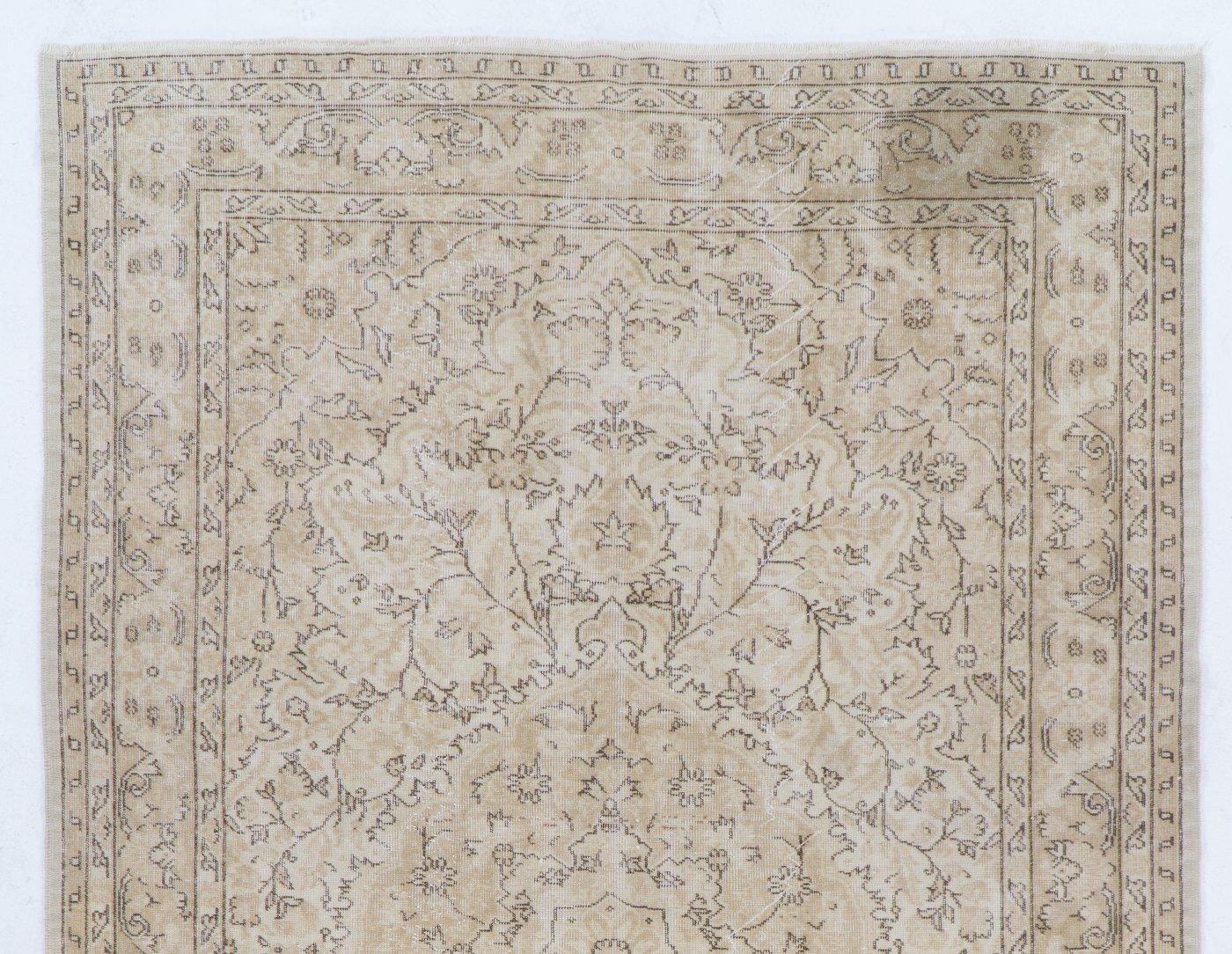 A finely hand-knotted vintage Turkish rug from the 1960s featuring a delicate all-over design of floral and leafy vines that look as though they are stenciled in a subtle, neutral color palette of cream, sand beige and brown. The rug has even low