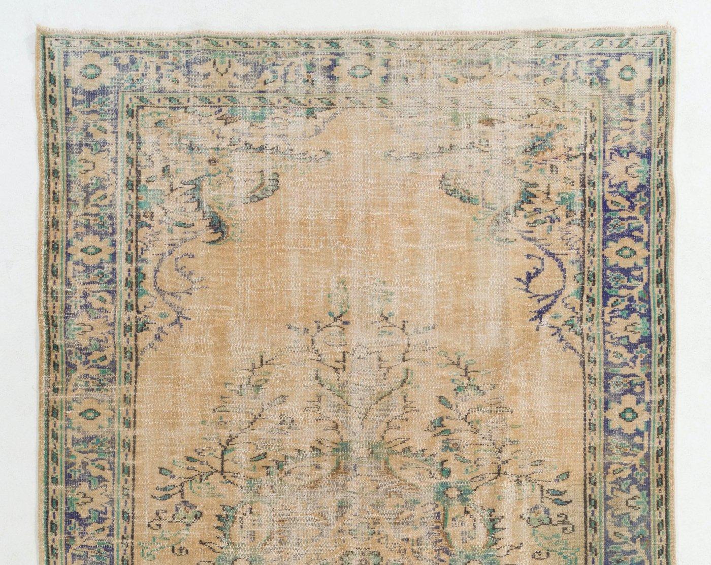 A finely hand-knotted vintage Turkish carpet from 1950s featuring an elegant medallion design. The rug has even low wool pile on cotton foundation. It is heavy and lays flat on the floor, in very good condition with no issues. It has been washed