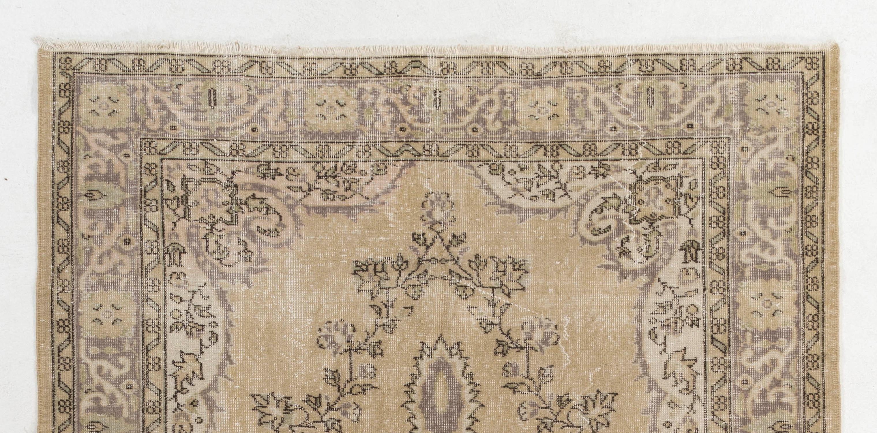 A finely hand knotted vintage Turkish carpet from the 1960s featuring an elegant medallion design decorated all around with a floral wreath in beige and taupe gray against a buttermilk yellow . The rug has even low wool pile on cotton foundation. It
