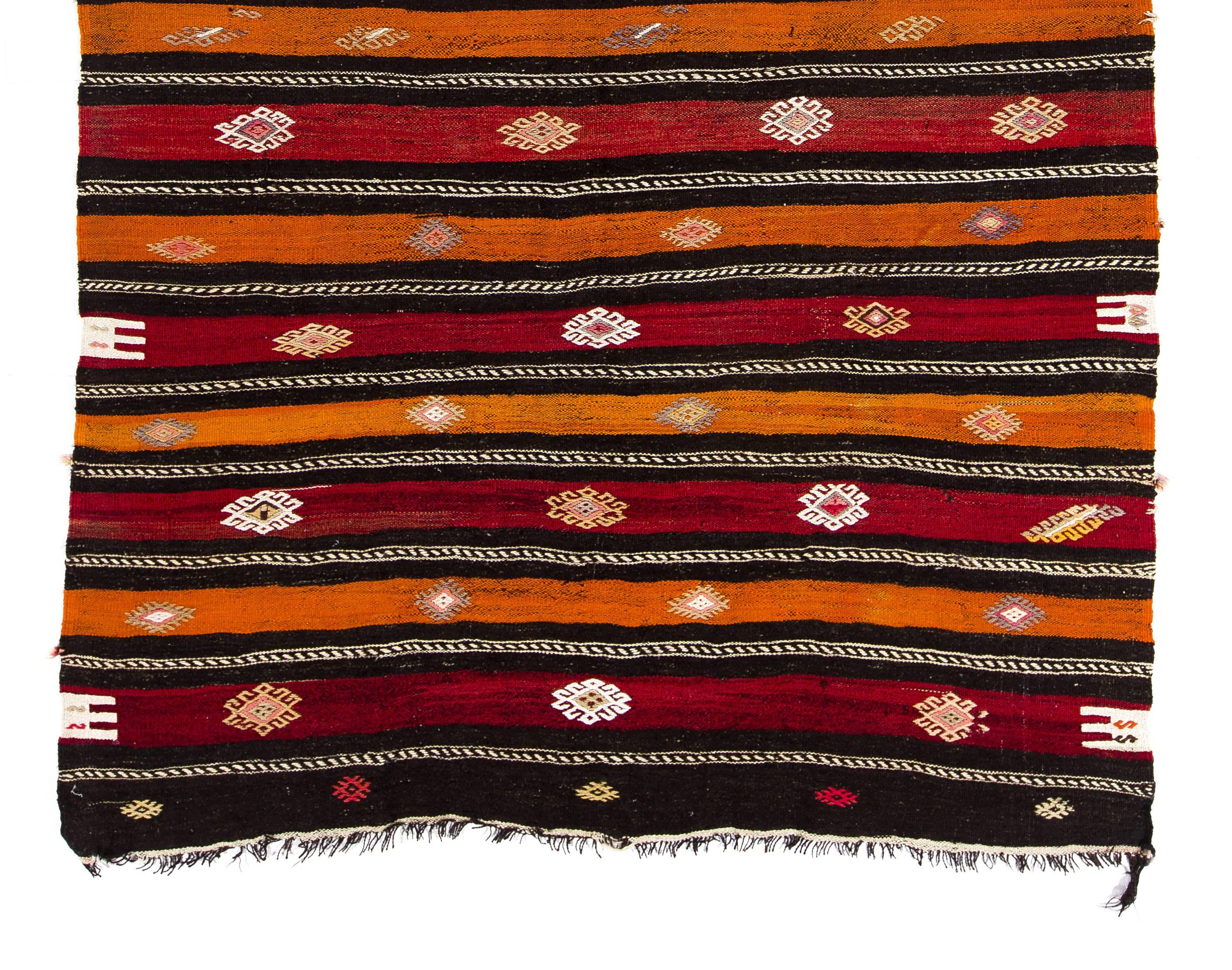 This authentic handwoven flat-weave (Kilim) from Central Turkey was made by Nomads to be used as a floor covering in their tents or summer houses circa mid-20th century. It is made of beautiful natural dyed red, terracotta, orange and undyed black