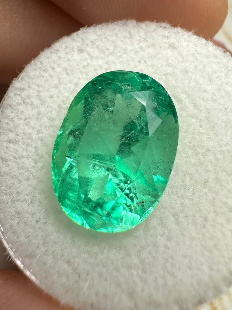 Stone: Emerald
Weight: 6.40-carats
Shape: Oval Cut
Clarity: Semi-Transparent
Luster: Very Good
Color: Medium Yellowish Green
Measurements: 13.64mm x 10.09mm x 8.21mm
Geographic Origin: Colombia
Treatment: Natural, Oiling

This emerald has a