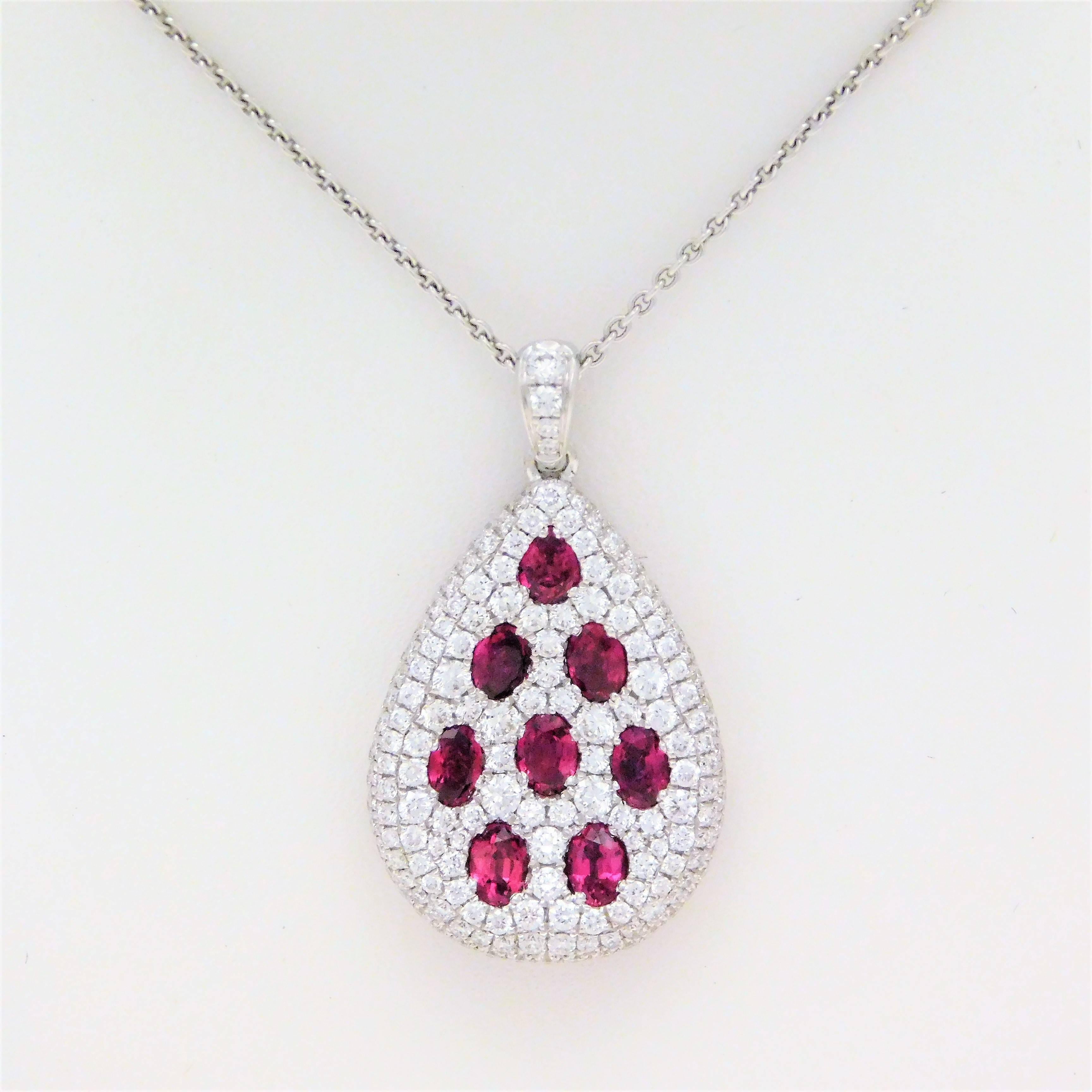 Circa 2018.  Handcrafted in solid 18k white gold, this set of two earrings and one pendant necklace has been designed to match perfectly.  Each earring, as well as the pendant, has been masterfully jeweled with 8 oval faceted rubies approximating