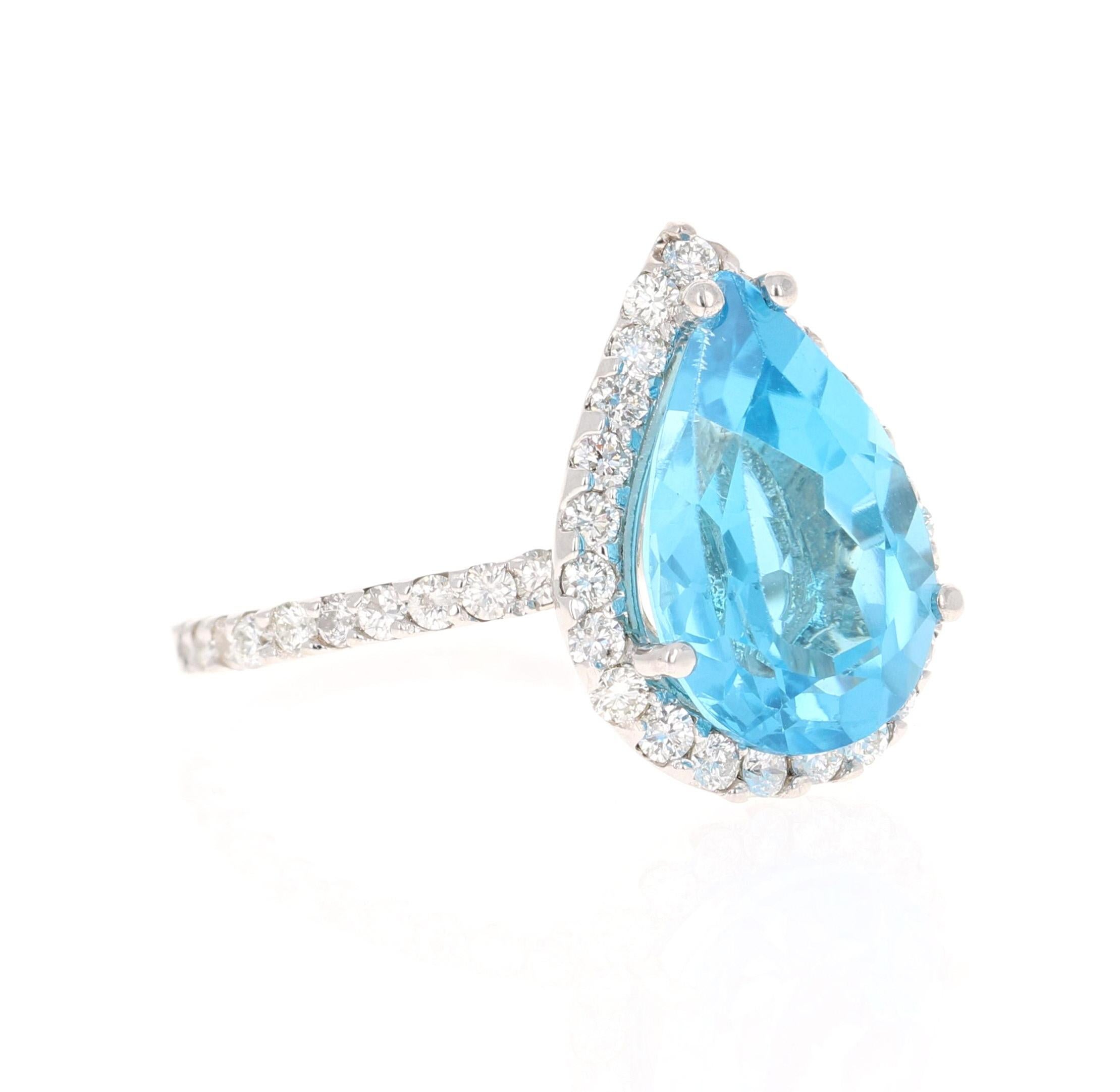 This stunning statement ring has a large Pear Cut Blue Topaz that weighs 5.60 Carats. 
It is surrounded by a simple halo of 45 Round Cut Diamonds that weigh 0.82 Carats. 

It is crafted in 14 Karat White Gold and weighs approximately 3.5 grams.