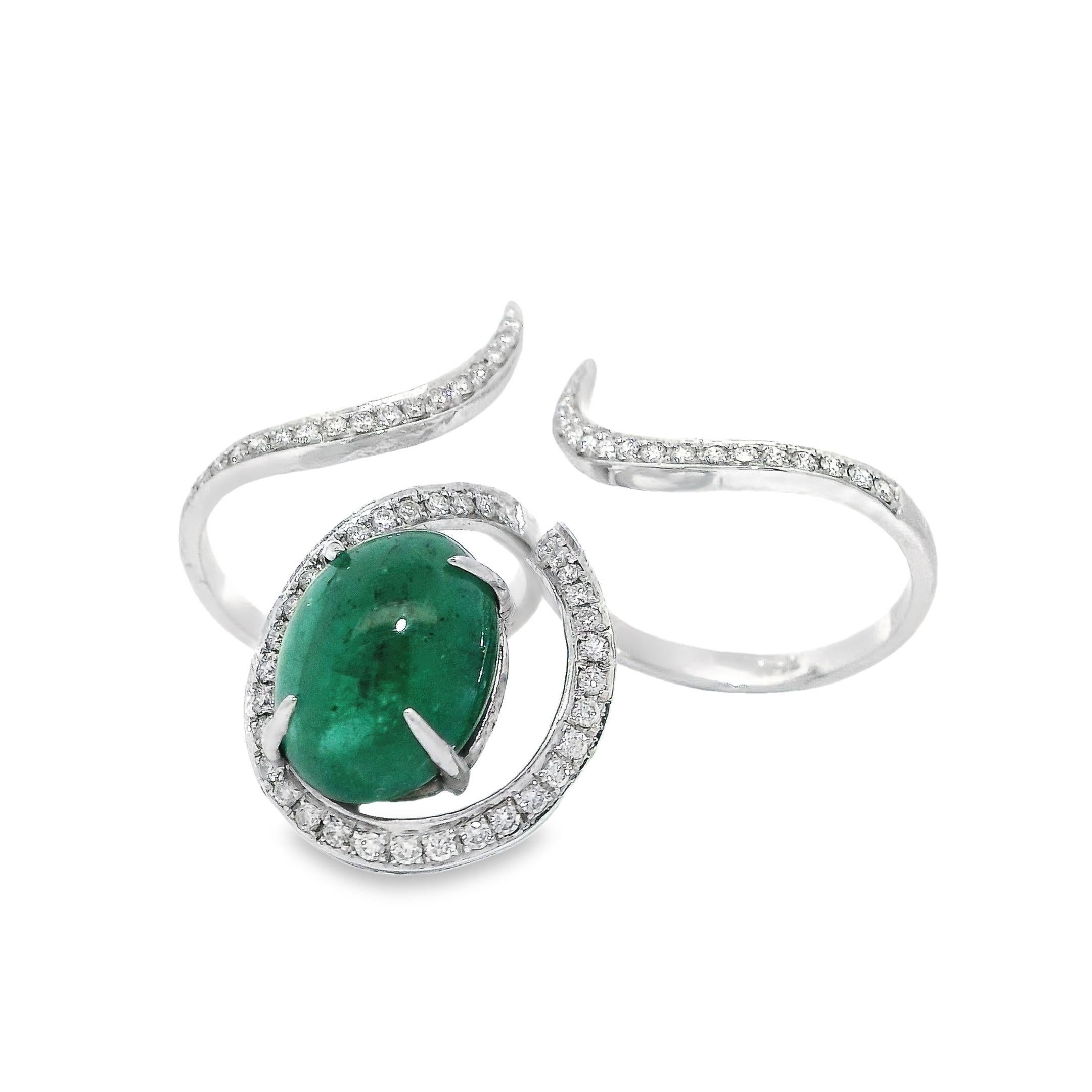 Treat yourself or a loved one to the quintessential symbol of luxury and elegance with this magnificent emerald ring. Standing out as the crown jewel, a radiant 6.43ct green cabochon emerald takes center stage, surrounded by a halo of glittering
