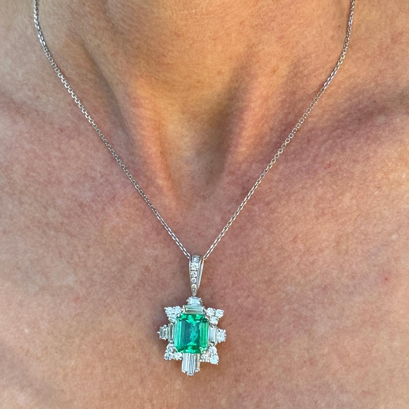 At the heart of this exquisite creation lies a magnificent Colombian emerald weighing 6.44 carats. This emerald possesses a rare and captivating allure, drawing the eye with its unparalleled beauty and depth.Surrounding the emerald are geometrically