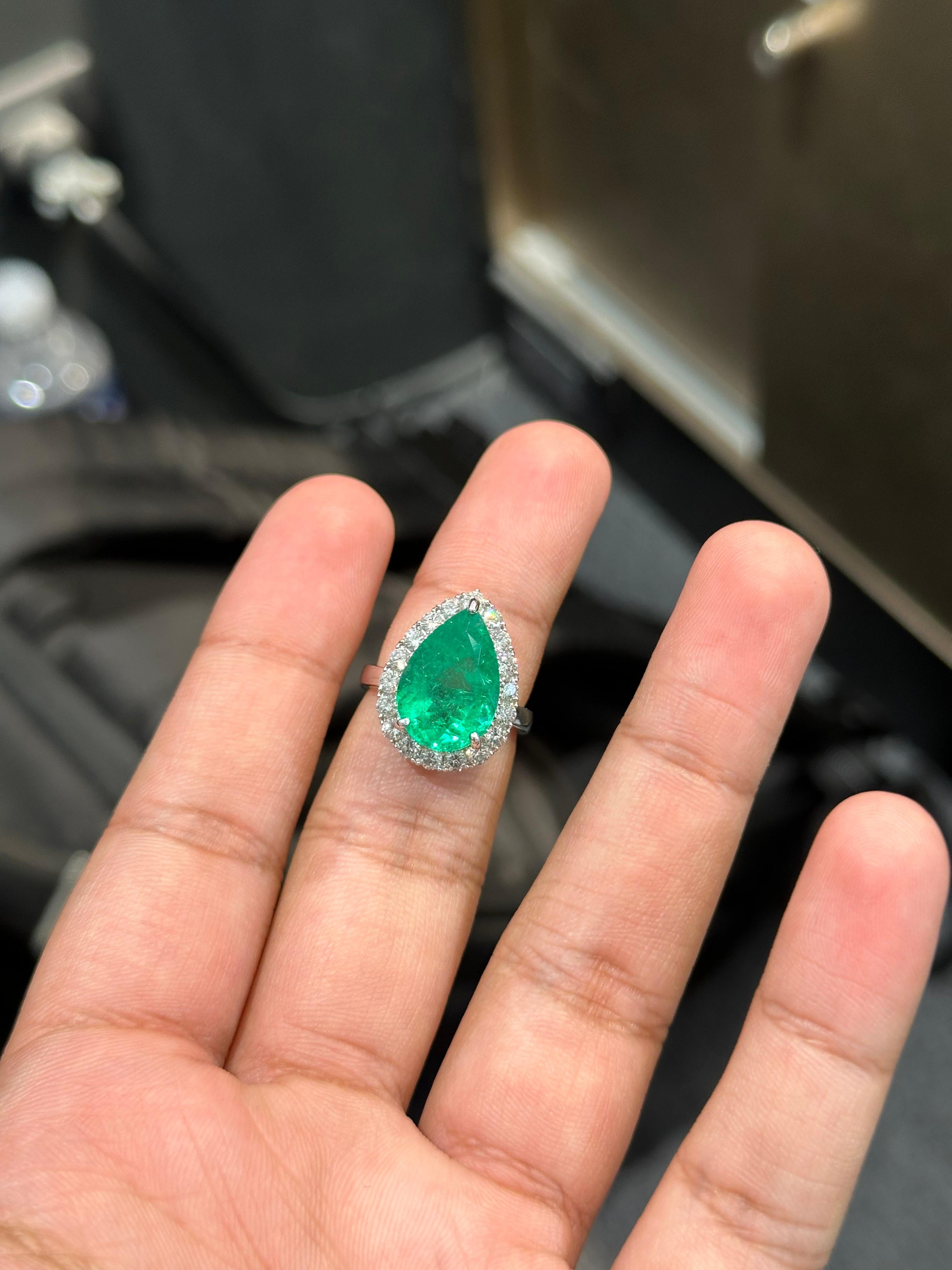 Introducing the epitome of luxury and sophistication, this classic Statement Ring!

At the center of this masterpiece lies a massive and resplendent 6.44 Carat pear-shaped Colombian Emerald gemstone. The emerald, known for its unparalleled elegance