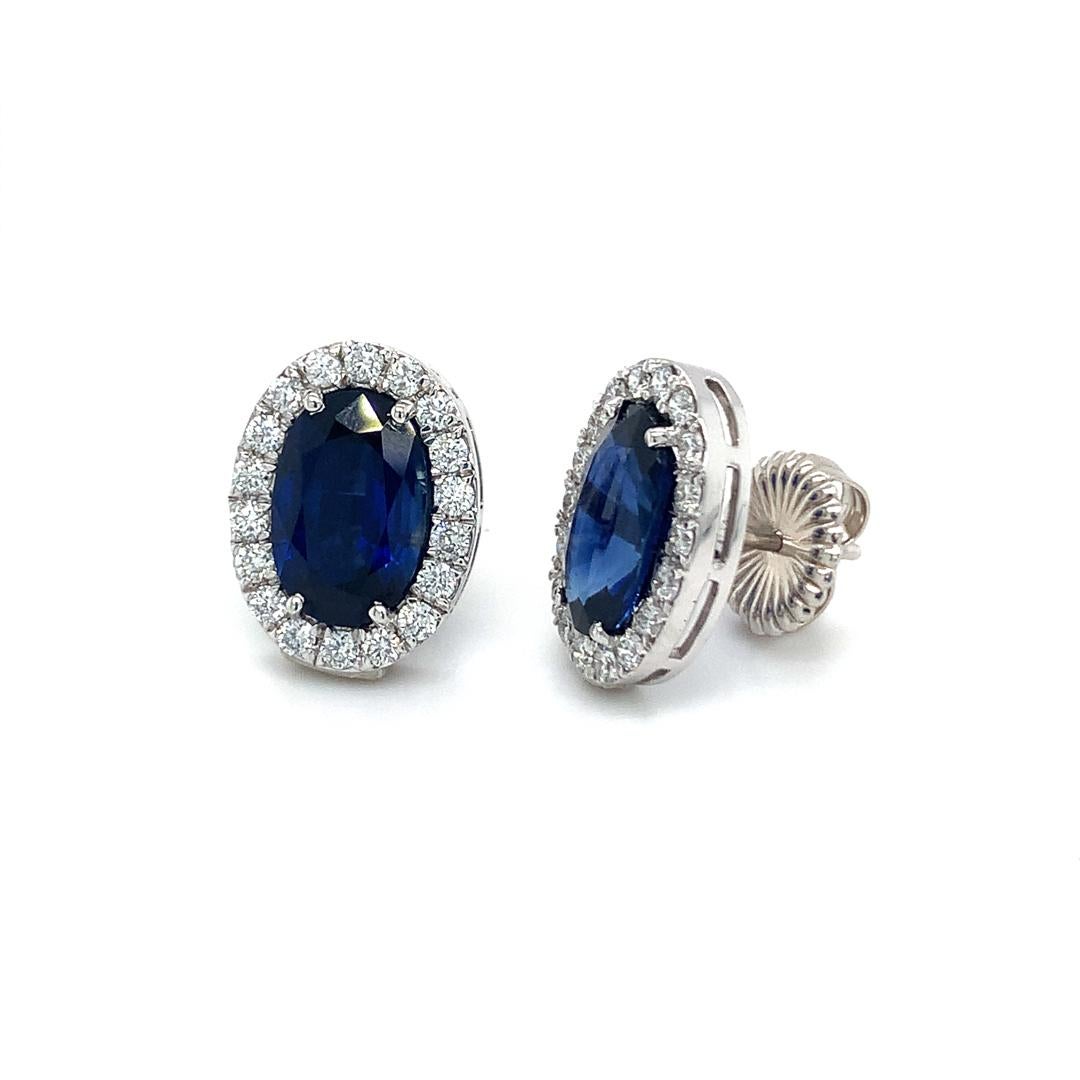 Natural 6.45 carat Natural Blue sapphire surrounded by 0.92 Carat diamonds Earring studs set in 18 Kt White gold.

