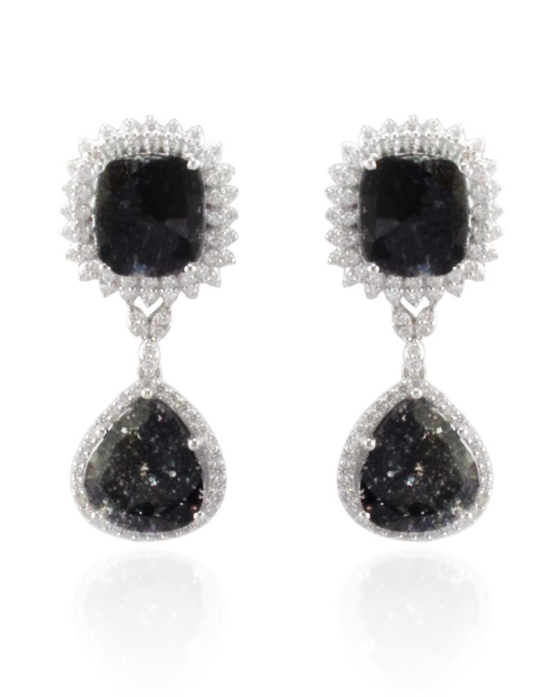 These are dangle earrings with 4 shimmering faceted fancy sliced black diamonds totaling 6.45 carats. These diamonds are framed by sparkling round brilliant cut white diamonds, prong set, around each one in a dazzling halo totaling 1.27 carats.