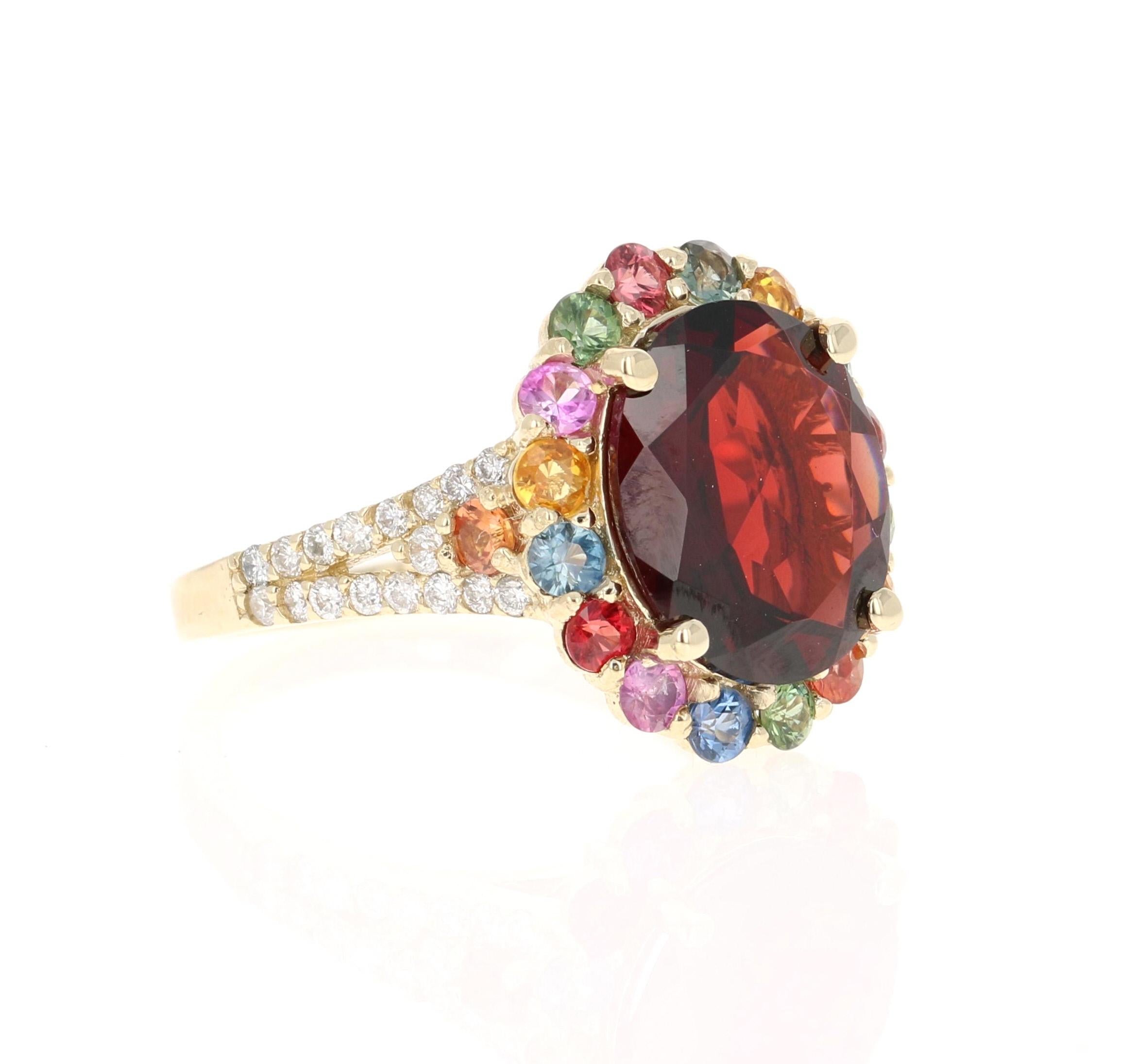 This ring has a Oval Cut Garnet weighing 4.80 carats and is surrounded by multicolored sapphires weighing 1.32 carats. In addition to the sapphires there are 34 Round Cut Diamonds that weigh 0.34 carats. The total carat weight of the ring is 6.46