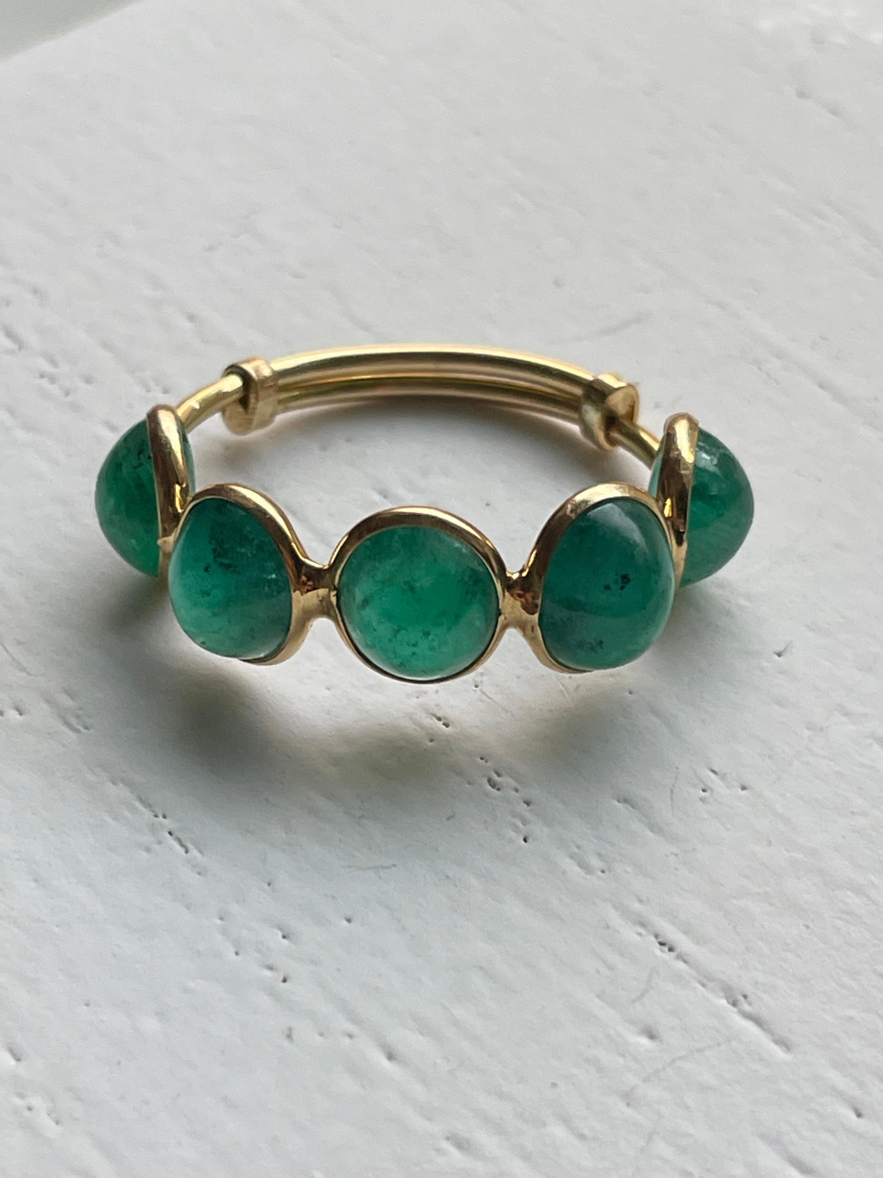 This gorgeous 18K Gold Cabochon Emerald Ring is comprised of 5 Emeralds. The stones are Oval cut and bezel set. When held to the light you will notice natural imperfections in the stones. These emeralds are ethically sourced in Colombia and hand set
