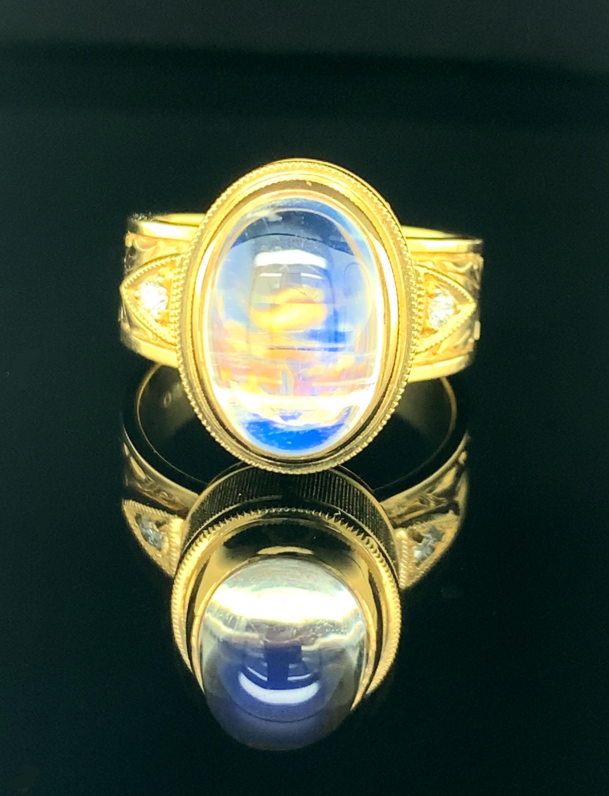 This elegant 18k yellow gold handmade ring features a 6.48 carat moonstone with gorgeous blue flash adularescence. Adularescence, or 