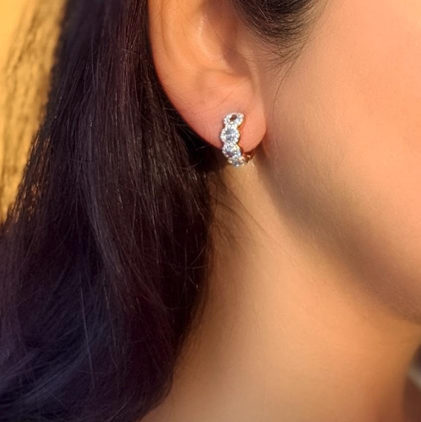 Delicate, light and luxurious, these versatile diamond huggie earrings can as easily be worn with jeans and a t-shirt as with a black tie gown. Round rose-cut diamonds are gently accented by smaller brilliant-cut diamonds in a pave setting, creating