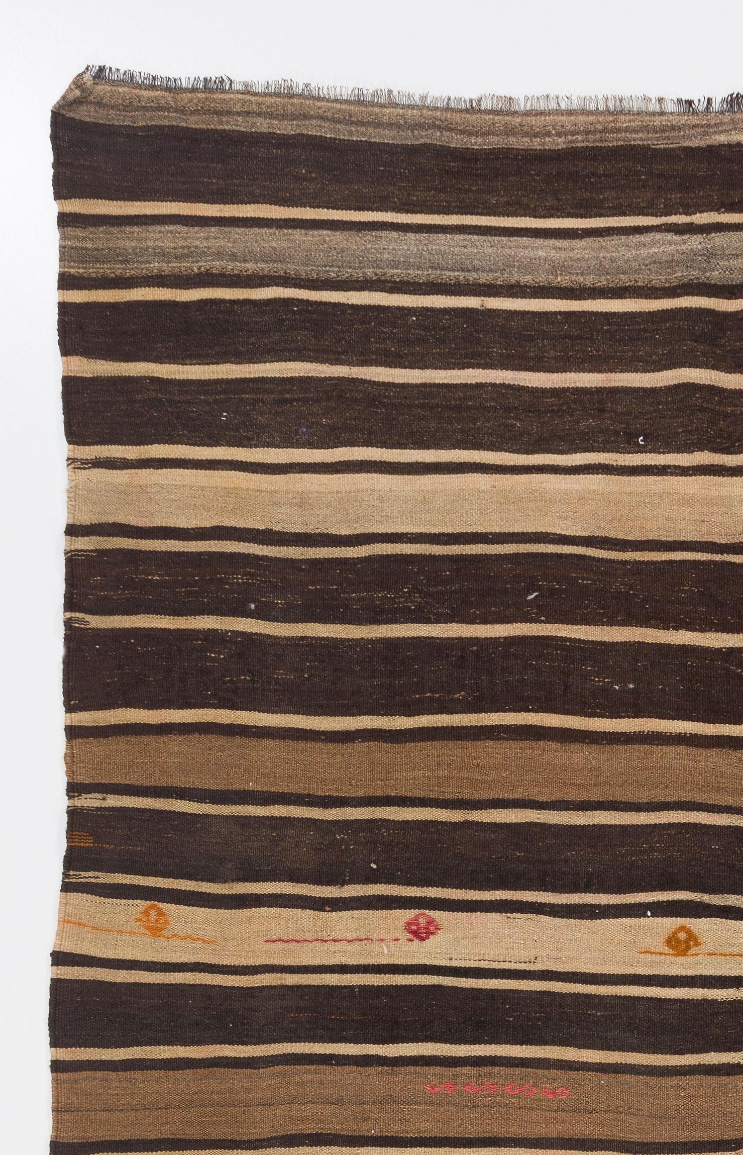A handwoven vintage banded central Anatolian kilim made entirely of un-dyed natural wool featuring earthy tones of light brown, dark brown and ivory. Dainty little brocades sparsely scattered across the kilim create an element of surprise and charm.