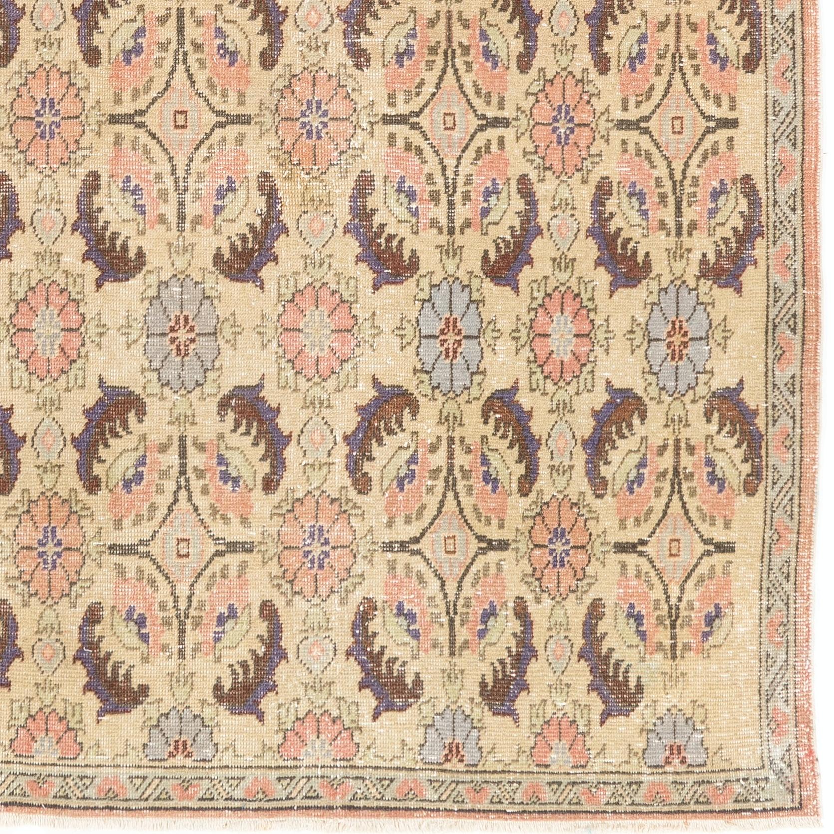 Tappeto turco annodato a mano della metà del XX secolo con un elegante disegno floreale art déco in una morbida tavolozza di colori pastello: beige, rosa corallo e azzurro. Il tappeto ha un vello di lana bassa su fondo di cotone, è in condizioni ben