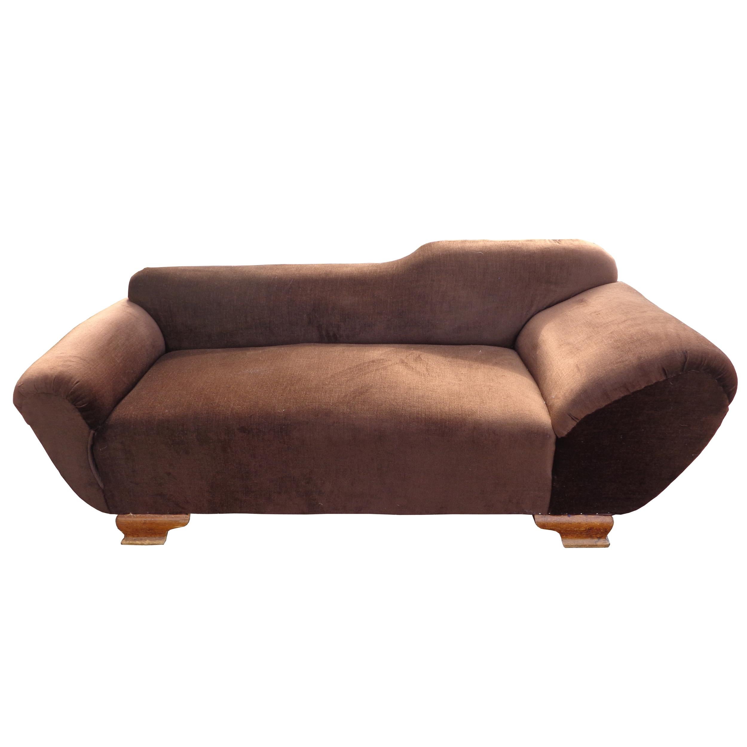 Art Deco Sofa
Asymmetrical armrests and the backrest give this sofa more of the
character of a chaise lounge for reclining as well as sitting.
Rich brown velvet. Pedestal style feet.