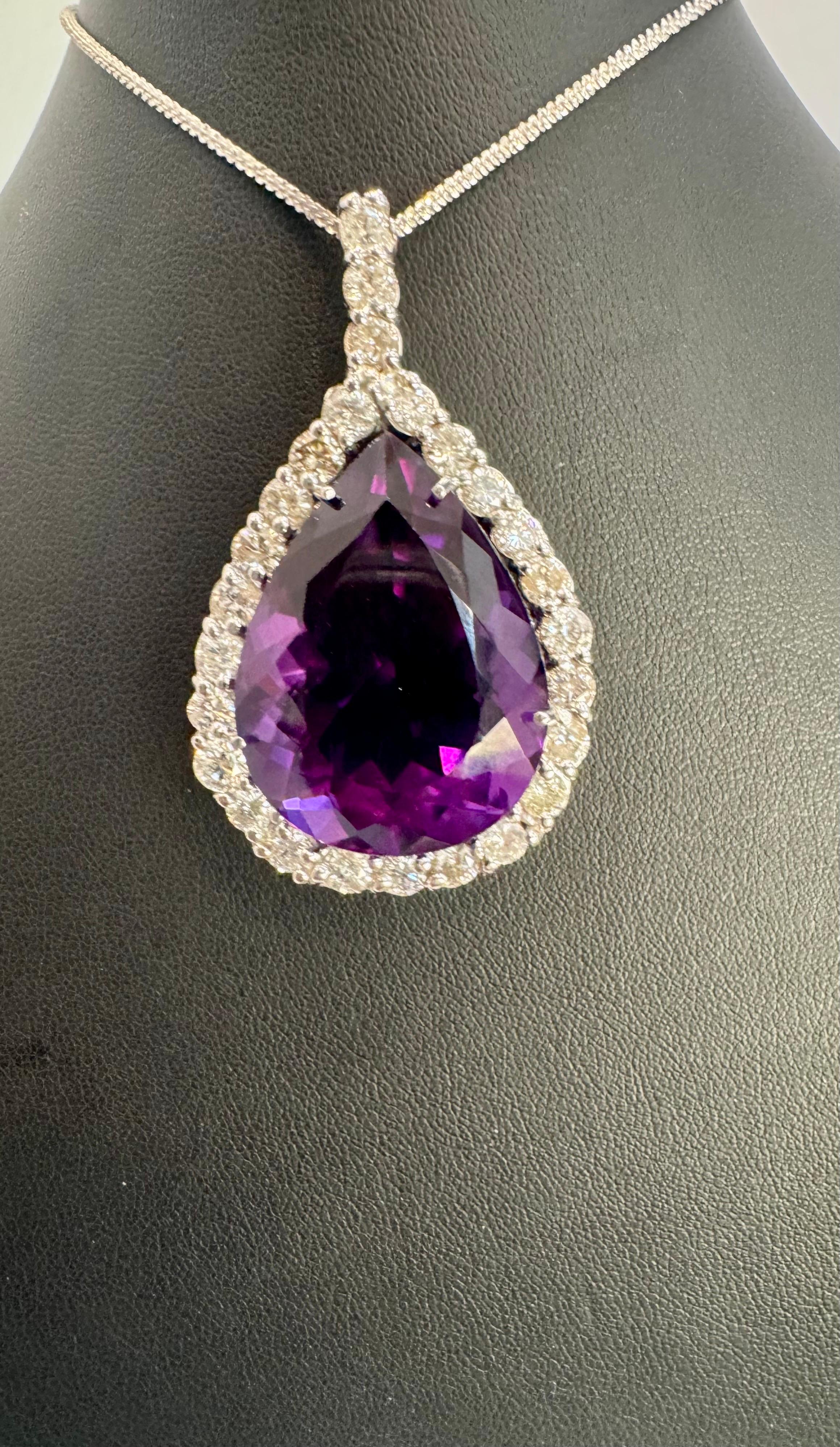   Environ  Collier pendentif améthyste 65 carats et diamant 8,5 carats or blanc 14 carats + chaîne
Ce spectaculaire collier à pendentifs  composé d'une seule grande améthyste poire, d'environ  65 Carat.  Le site  Améthyste   Elle est entourée de