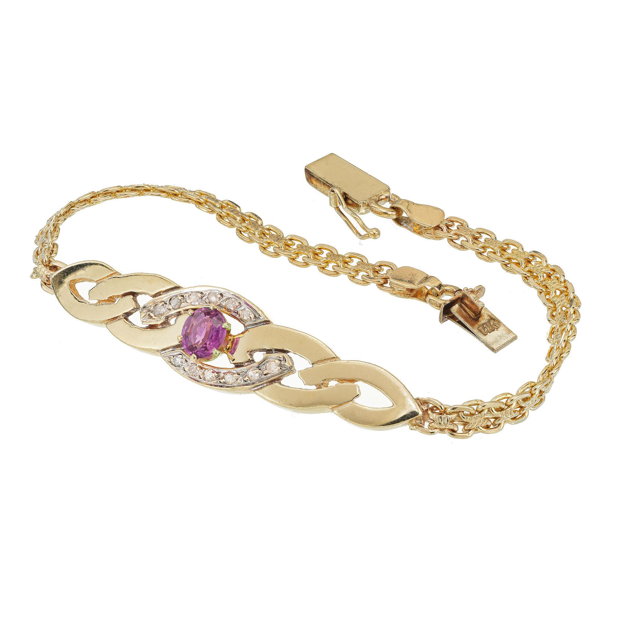 Pink Tourmaline and diamond bracelet. Swirl design center plaque, with 12 round accent diamonds with a 14k yellow gold Bismark style chain with box catch and safety. 6.5 inches. 

1 round pink Tourmaline approx. total weight .65cts
12 round diamonds