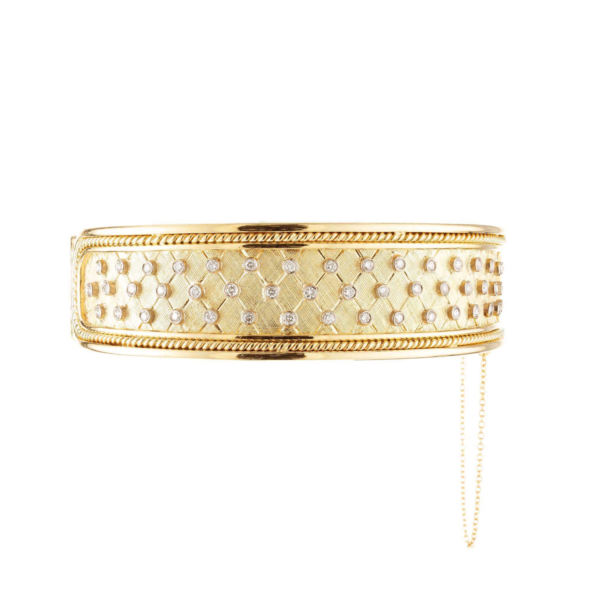 1980's handmade bangle diamond bracelet. This textured trellis style 14k yellow gold bangle bracelet is adorned with 49 round cut diamonds that are set in 14k white gold bezels on the front side with the same pattern repeated on the back side with