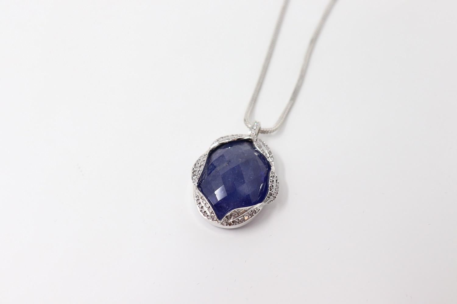 Beautiful and rare necklace in 18kt white gold with a large 65 ct Tanzanite pendant. The pendant is surrounded by brilliant cut diamonds. Total weight 16 gr.