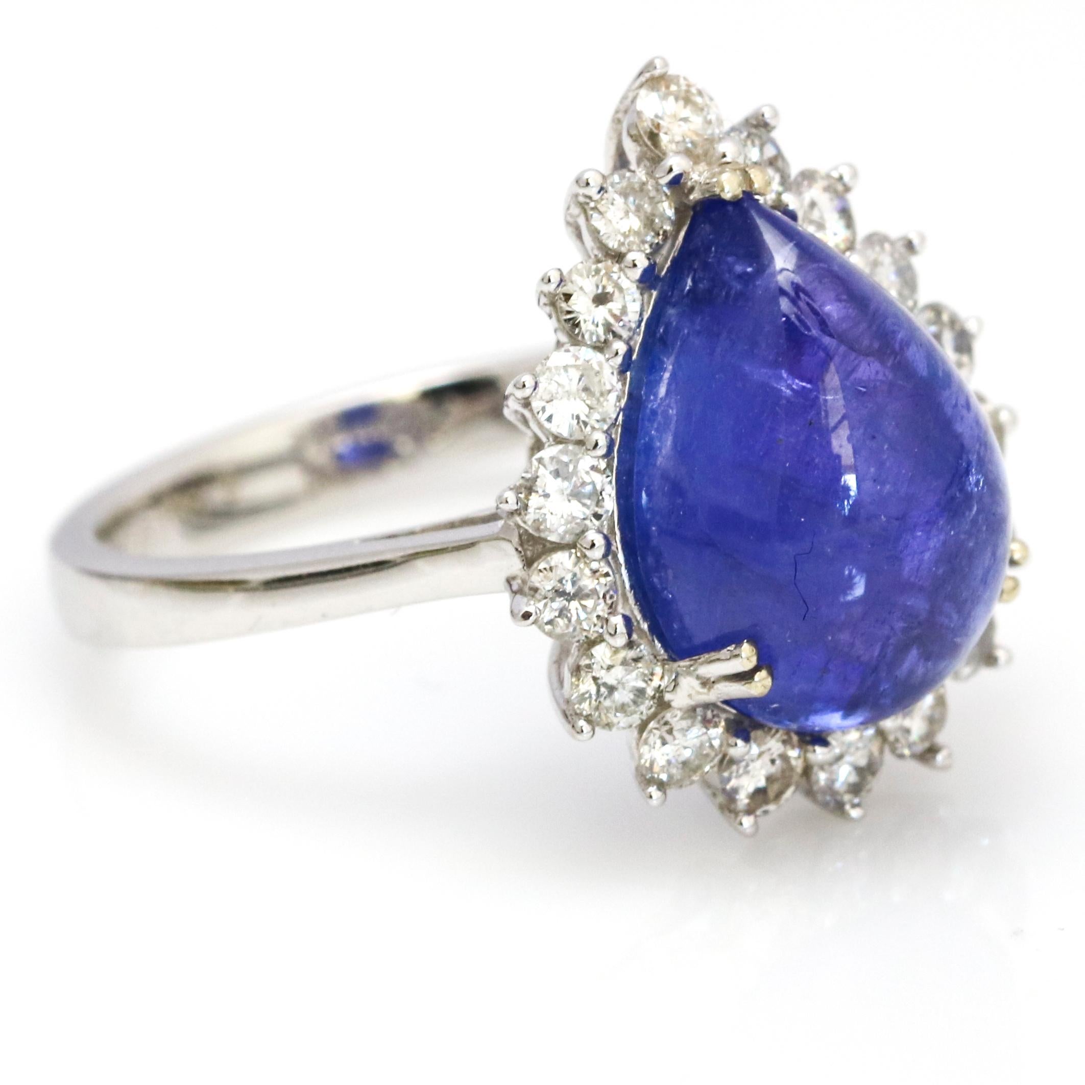 Tanzanite and diamond ring in 14-karat white gold. The ring has a pear cabochon cut natural  Tanzanite center surrounded by diamonds. 

Size, 7 (can be resized)
Gemstone (Tanzanite) total carat weight, 6.00 carats
Diamond total carat weight, .30