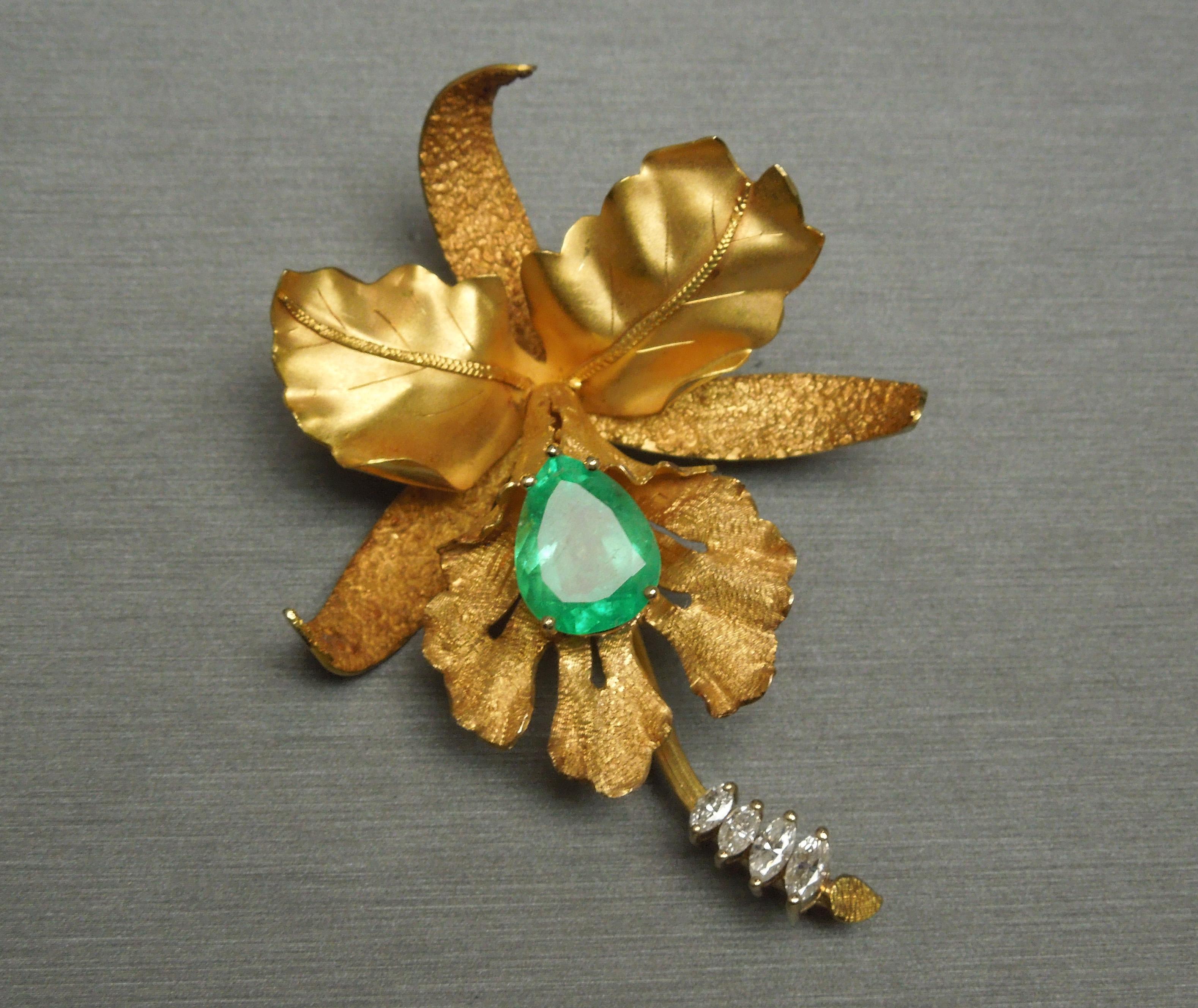 This 18KT Gold Emerald Orchid brooch [doubling as a pendant if desired] features a central 6.50 carat Pear cut Brilliant Green Emerald at 14mm x 10.8mm, securely set in a 5-prong head. Slight haze to Emerald - simply a characteristic of naturally