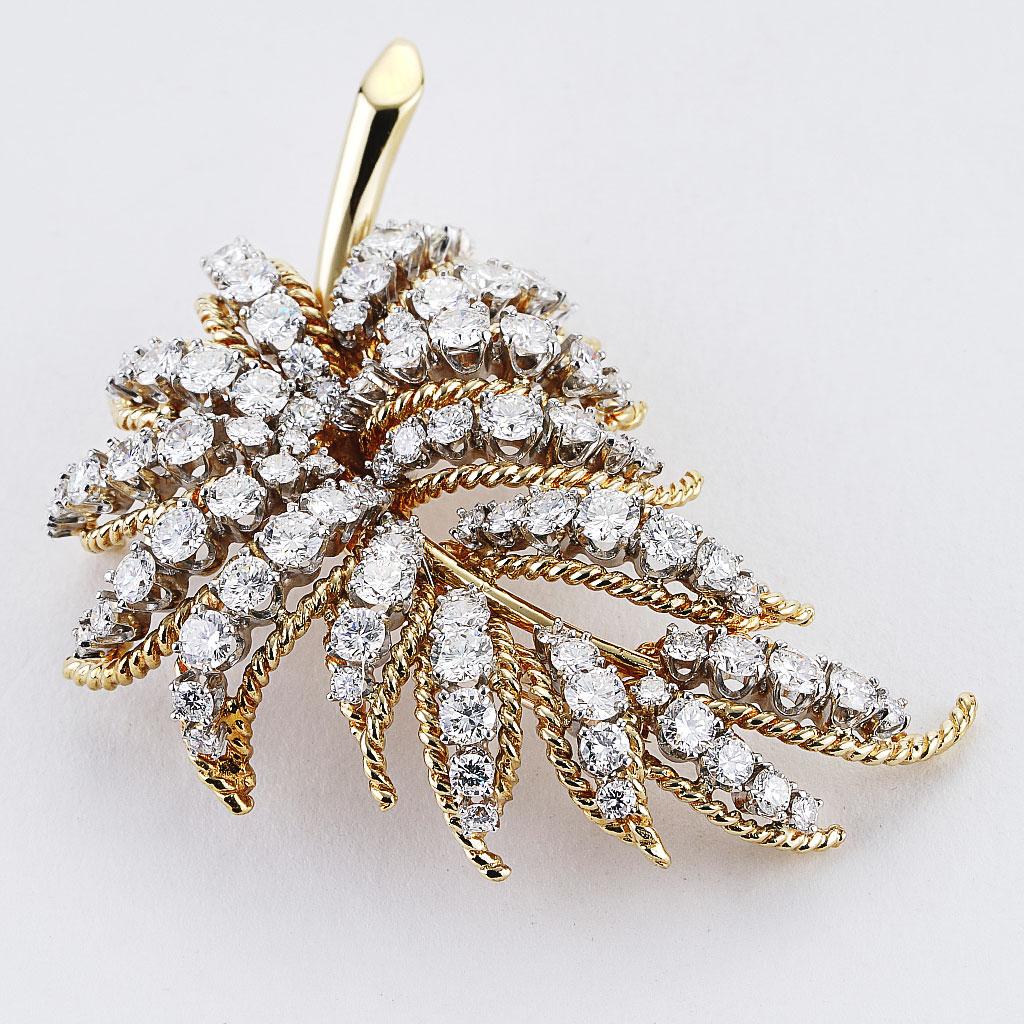 This vintage style pin is made of 18k yellow gold and weighs 15.00 DWT (approx. 23.33 grams). It contains 93 round G color and VS clarity diamonds weighing 6.50 CTTW. this piece measures 2 inches by 1.25 inches.